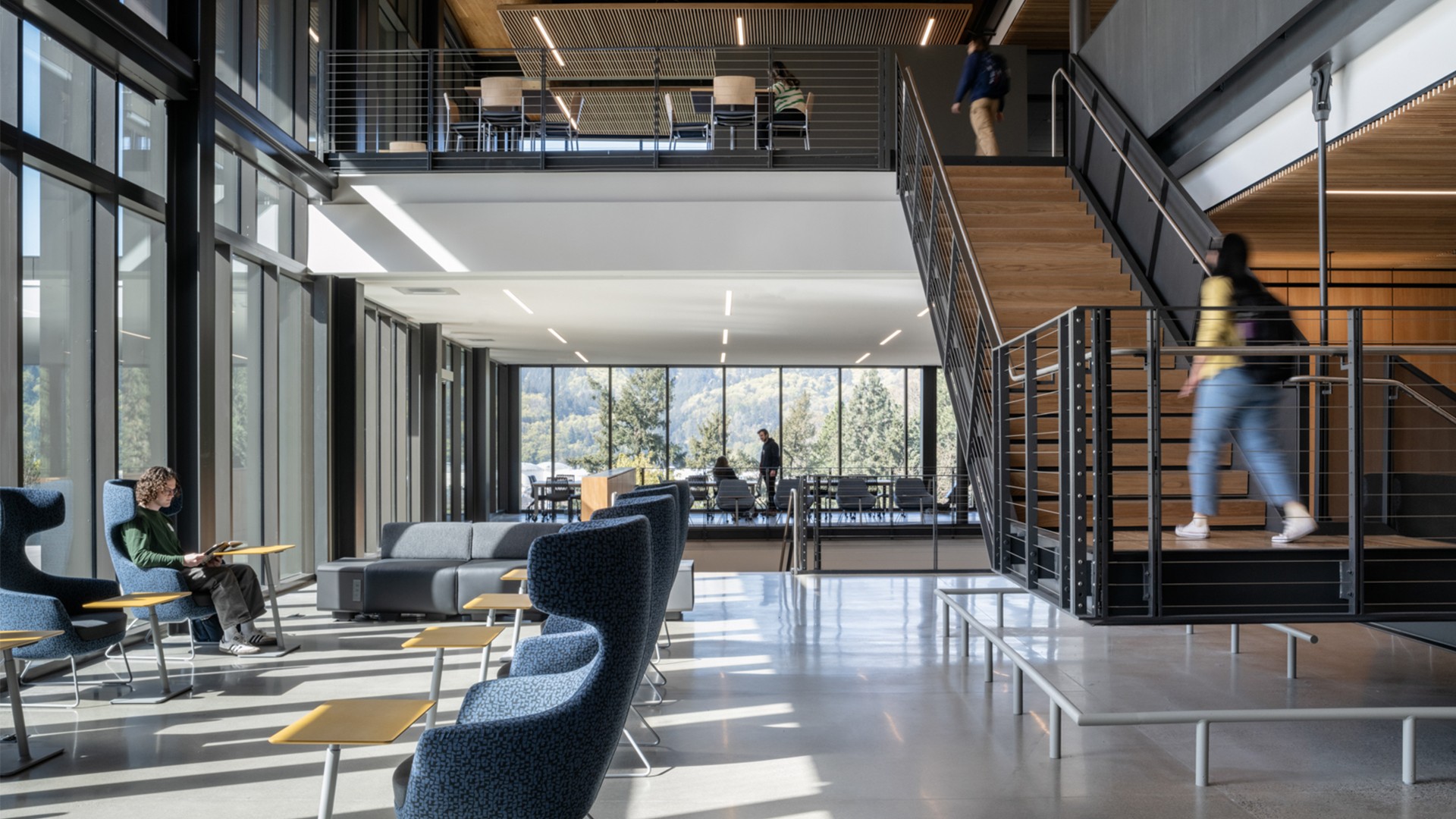Modern office interior with large windows, comfortable seating, and natural light.