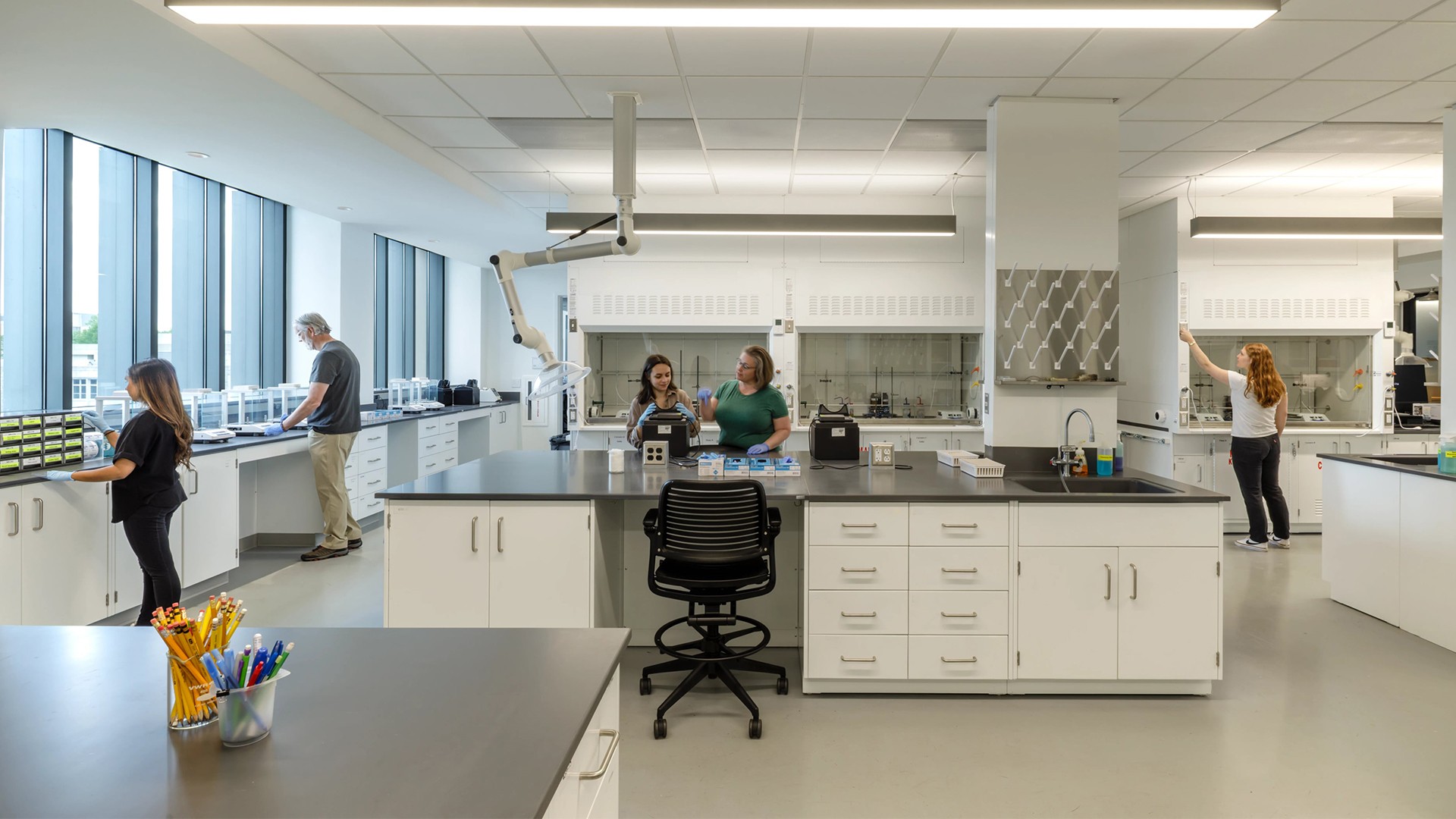 Modern laboratory with scientists working and advanced equipment on clean counters.