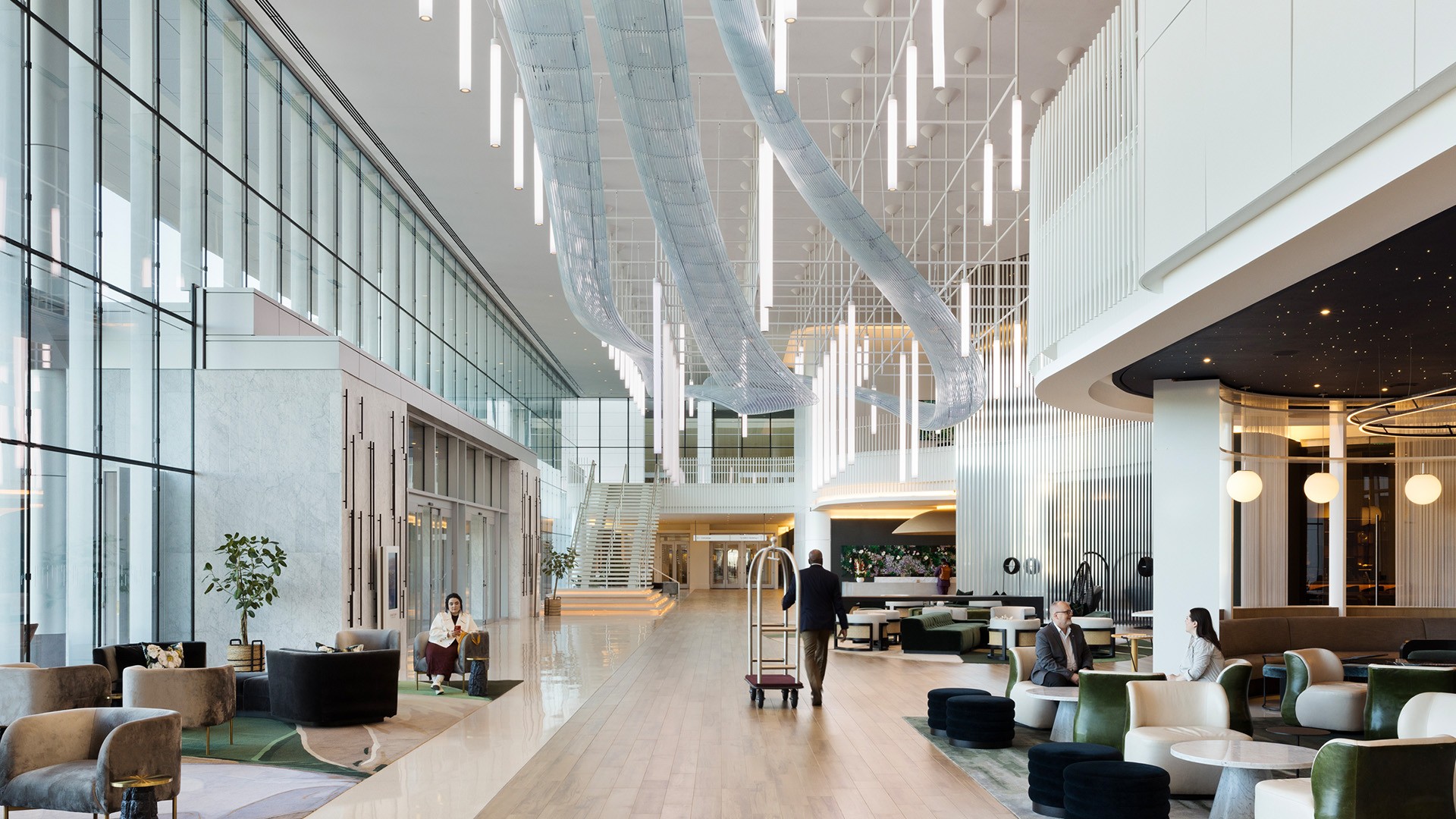Modern hotel lobby with high ceilings, large windows, and stylish seating areas.
