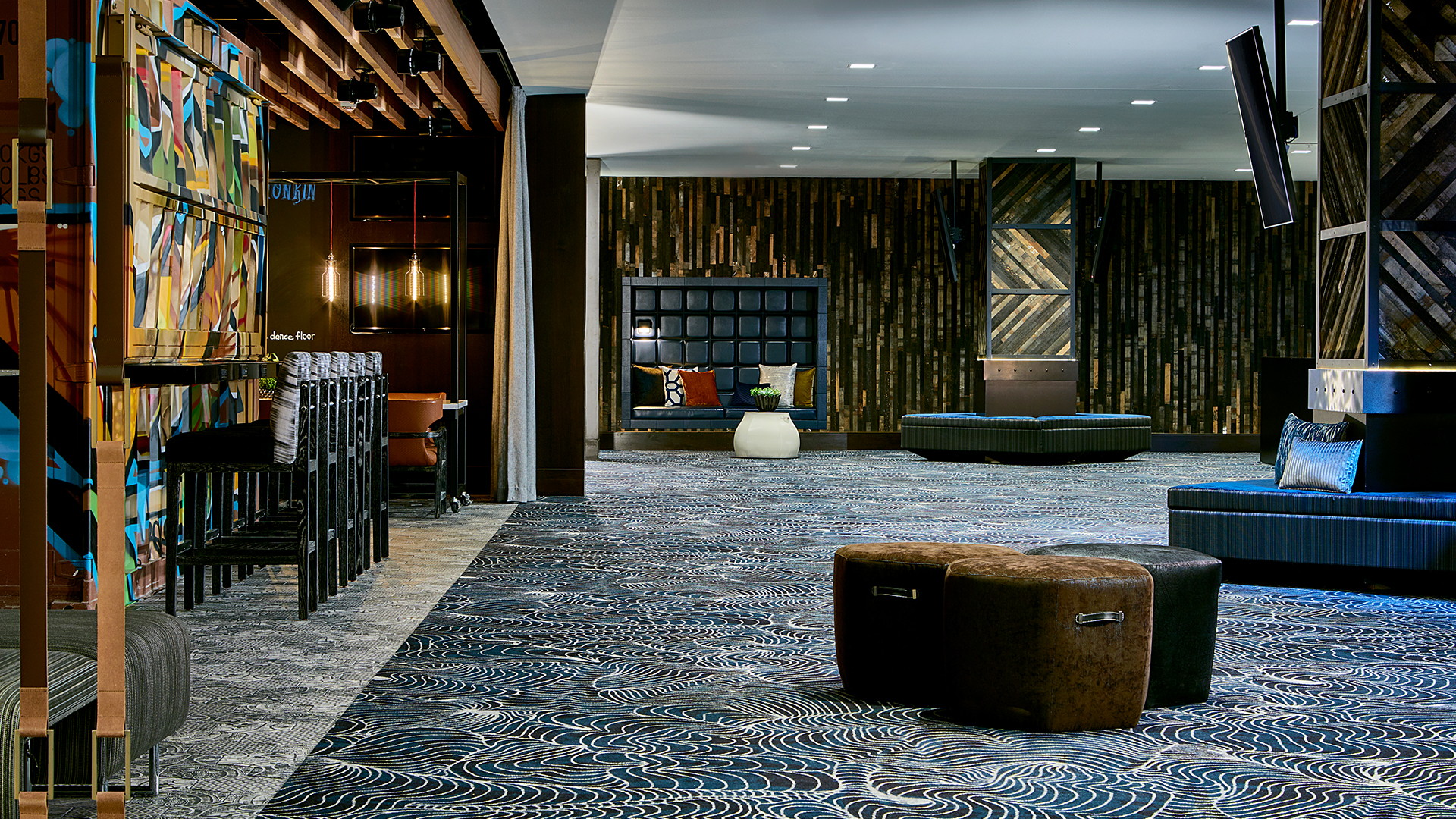 Modern hotel lobby with patterned carpet, stylish seating, and ambient lighting.