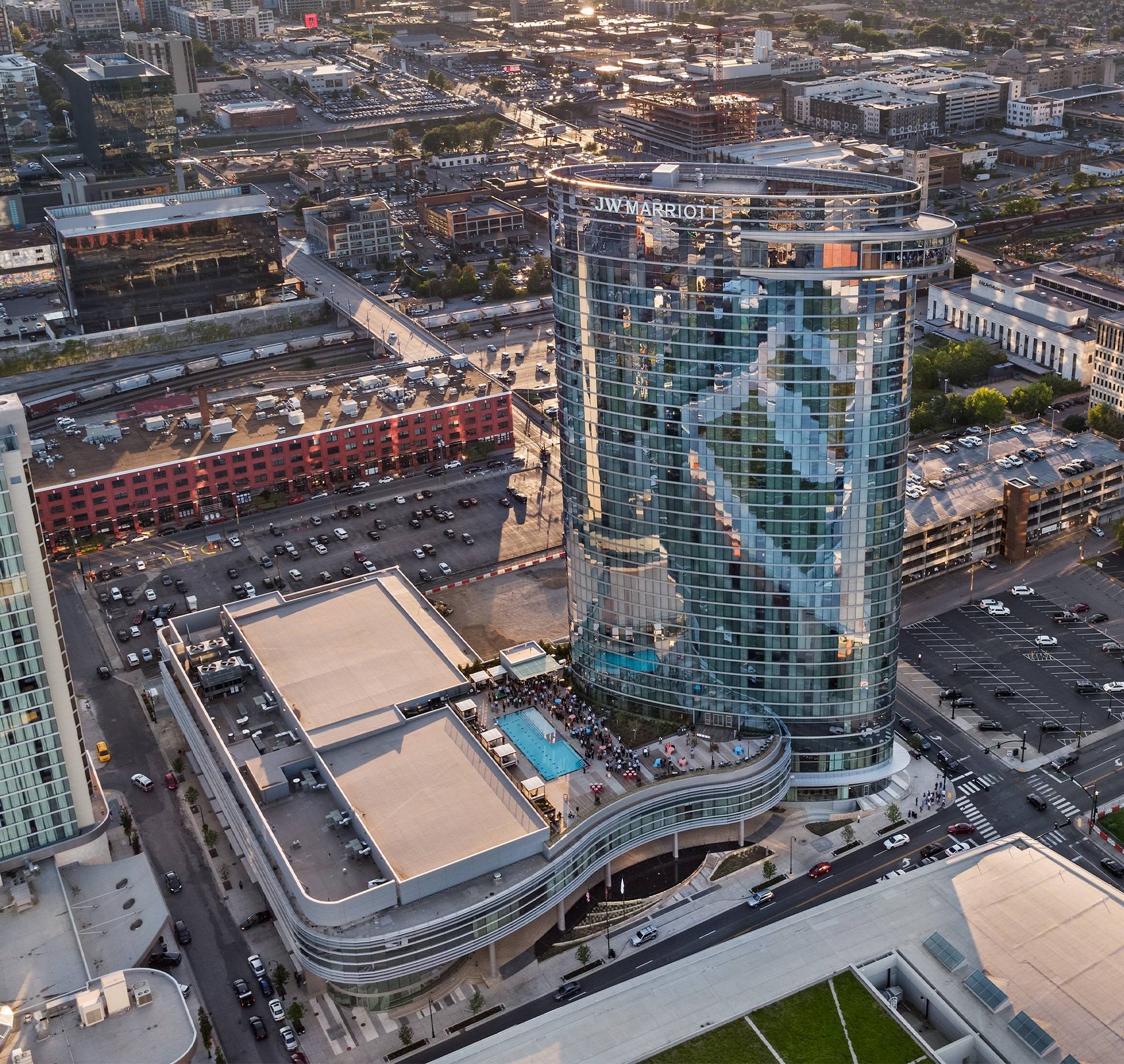 JW Marriott Hotel Tower with Pool in Urban Downtown Area Aerial view of JW Marriott hotel with glass facade and rooftop pool in urban cityscape.