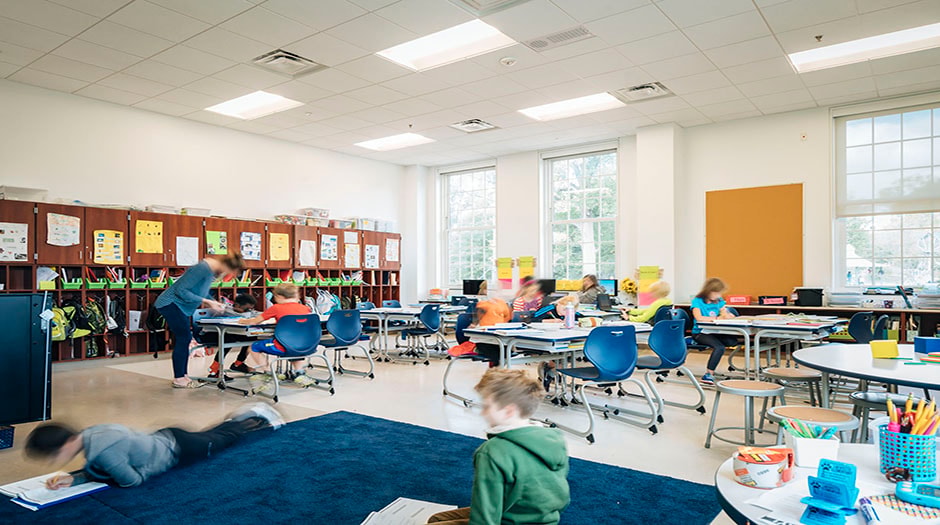 Modern classroom with students engaging in activities; features bright lighting and organized seating.