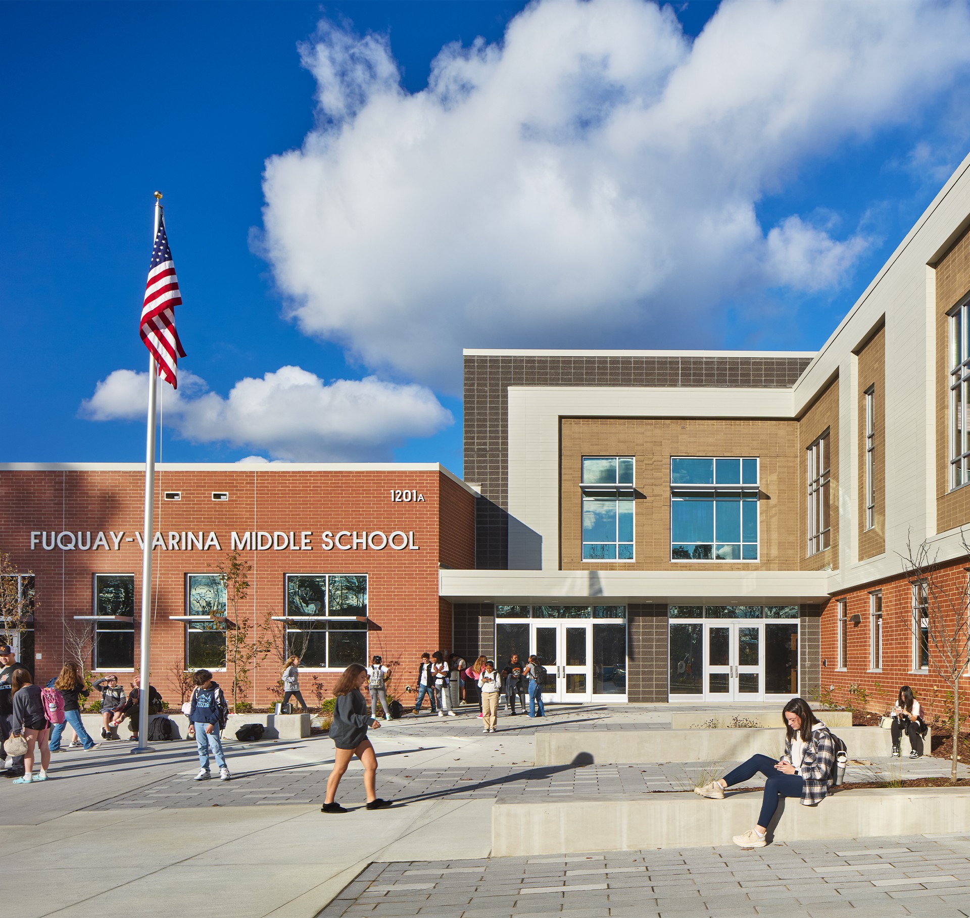 Fuquay-Varina Middle School Building with Students Outdoors Fuquay-Varina Middle School building with students and American flag on a sunny day.