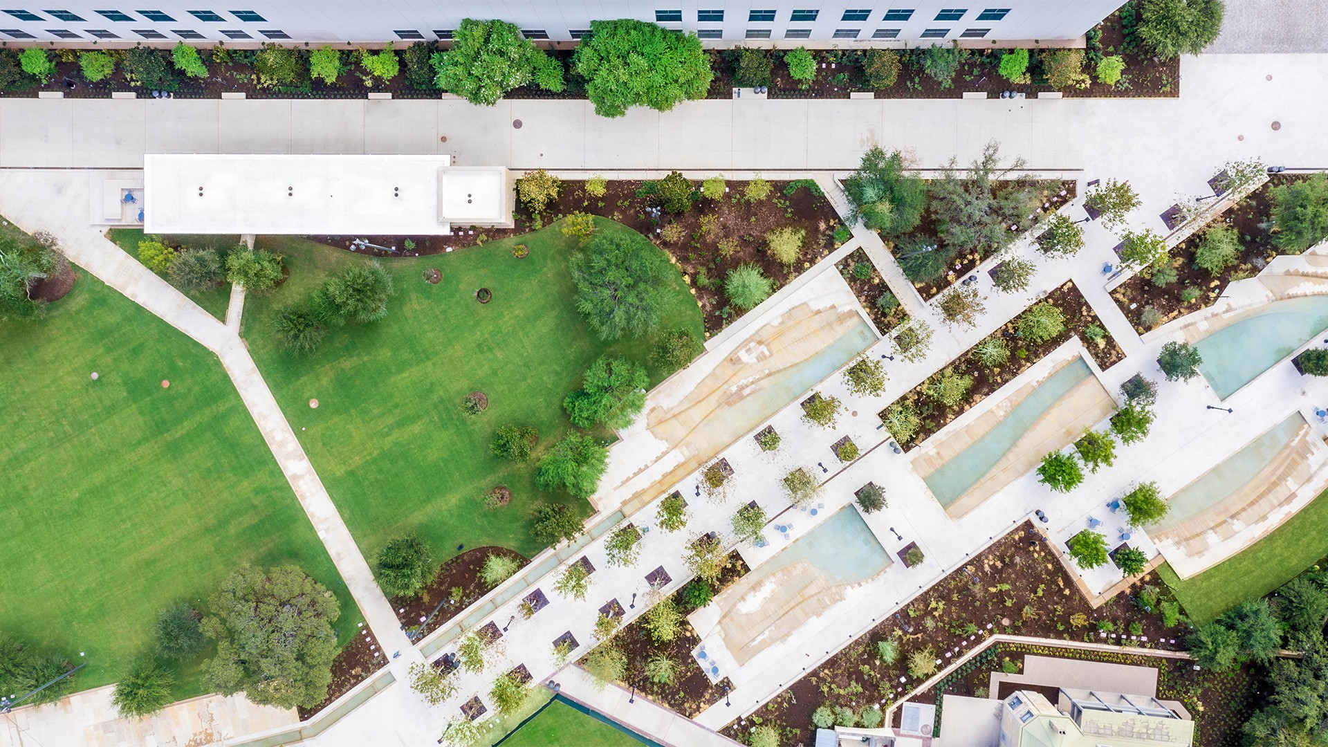 16x9 Aspect Ratio: 1920x1080 Resolution Template Design Aerial view of a landscaped urban park with paths, greenery, and modern architectural design.