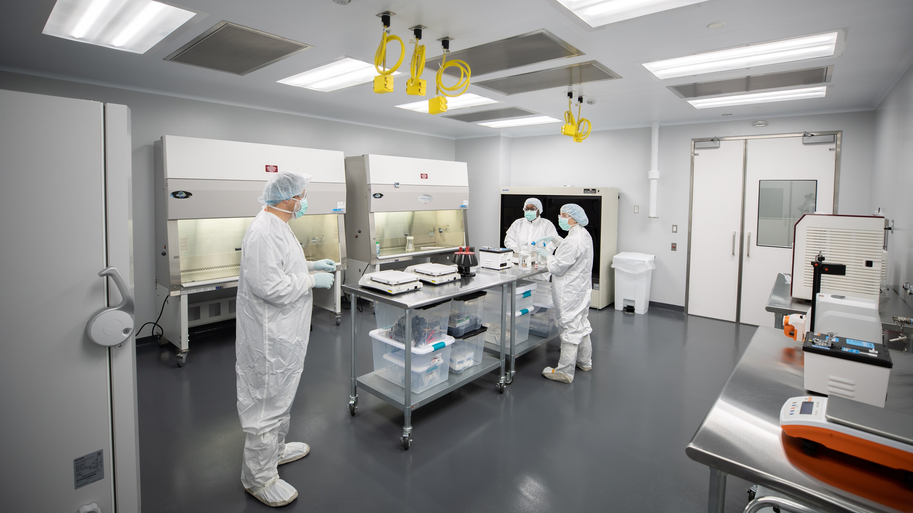 Laboratory Scientists Working in a Sterile Cleanroom Environment Scientists in full protective gear working in a sterile, modern laboratory environment.
