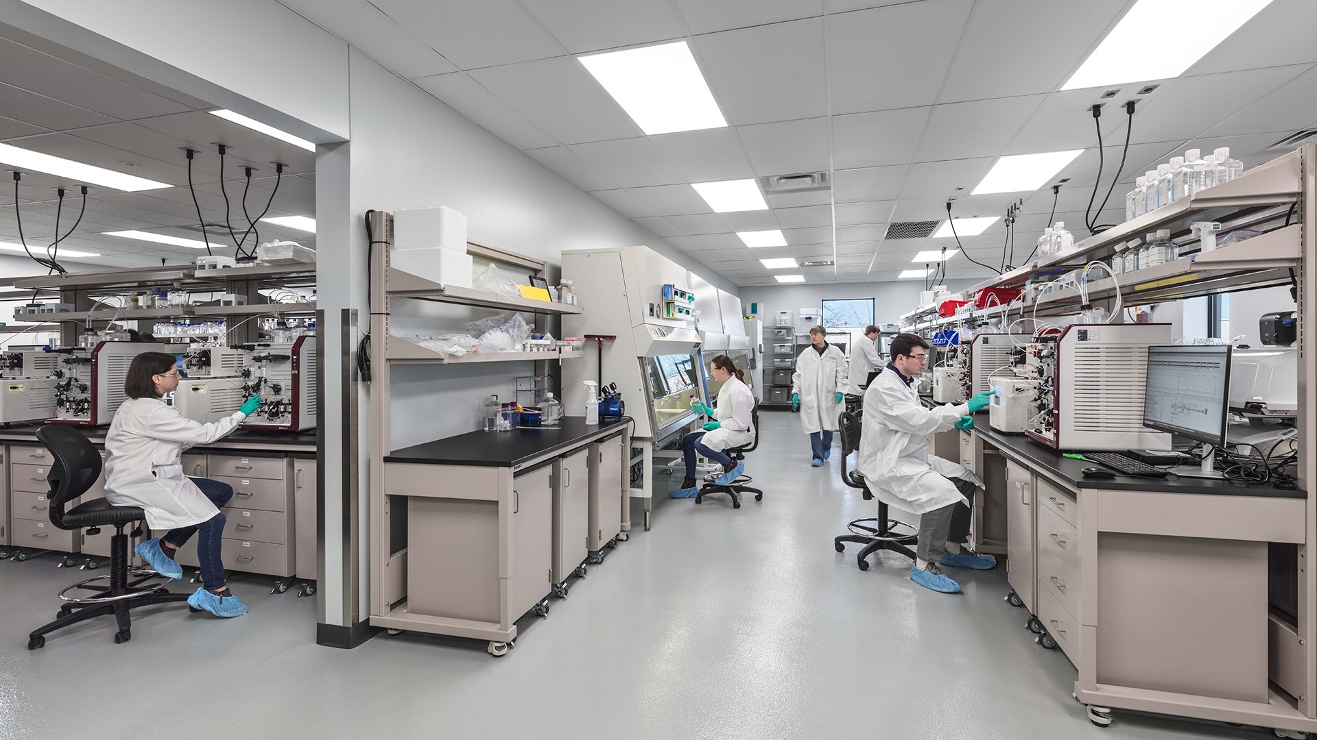 Modern Laboratory with Scientists Working on Advanced Equipment Modern scientific laboratory with researchers working on advanced equipment and computers.