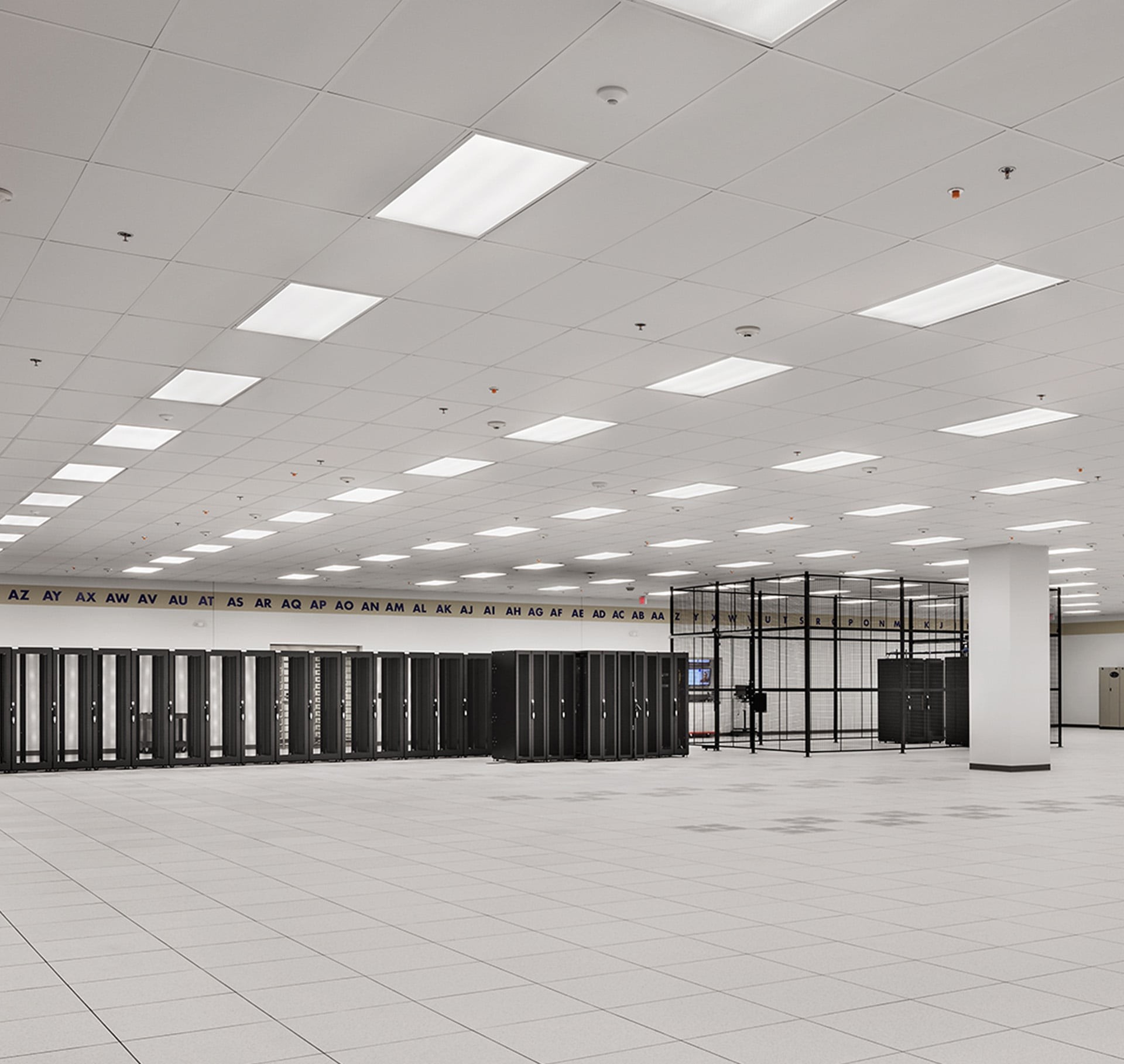 Modern Data Center Server Room with Advanced Equipment Rows Spacious, modern data center with rows of black server racks and bright ceiling lights.