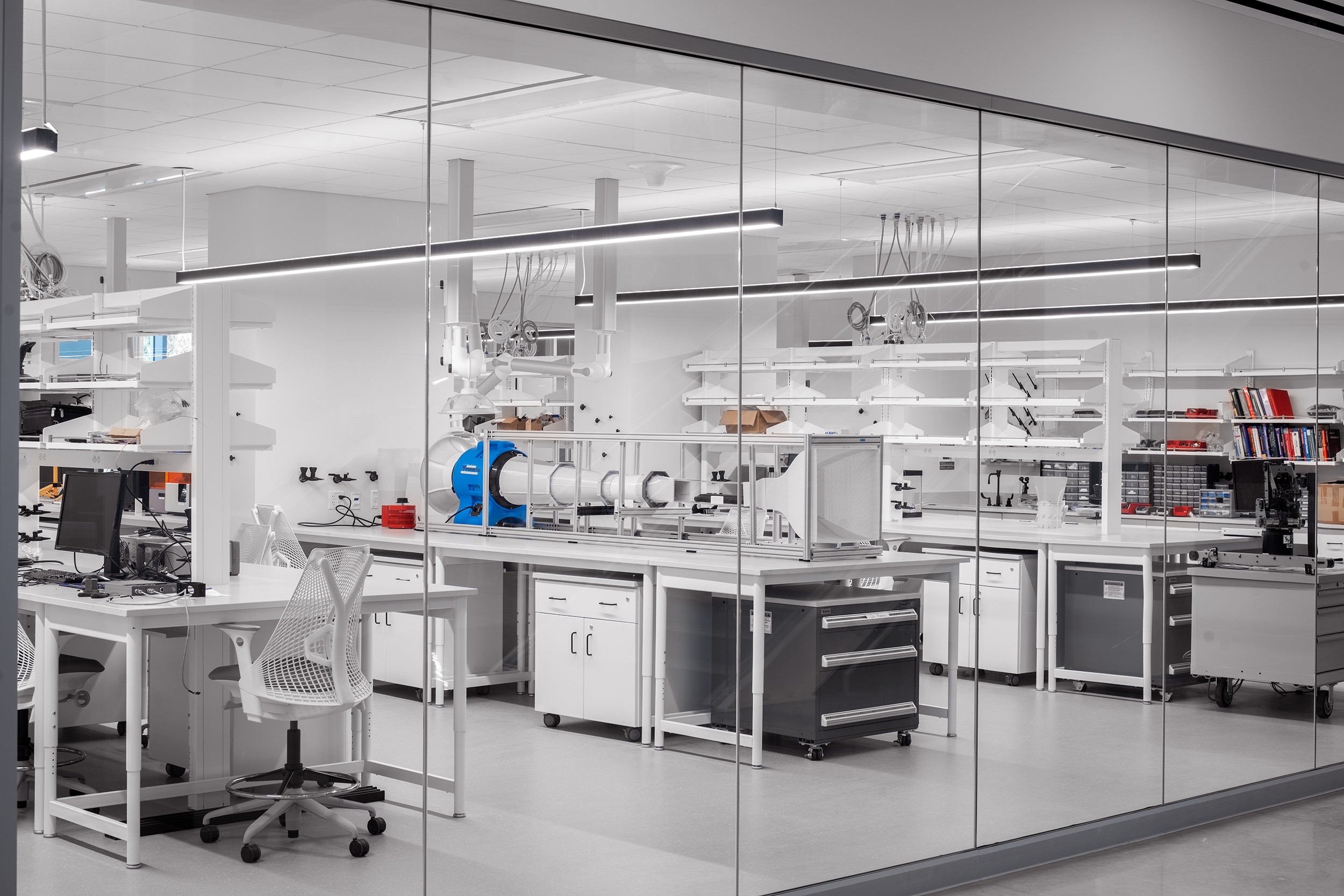 Modern Laboratory Workspace with Advanced Scientific Equipment Modern laboratory interior with clean workstations, equipment, and glass walls.