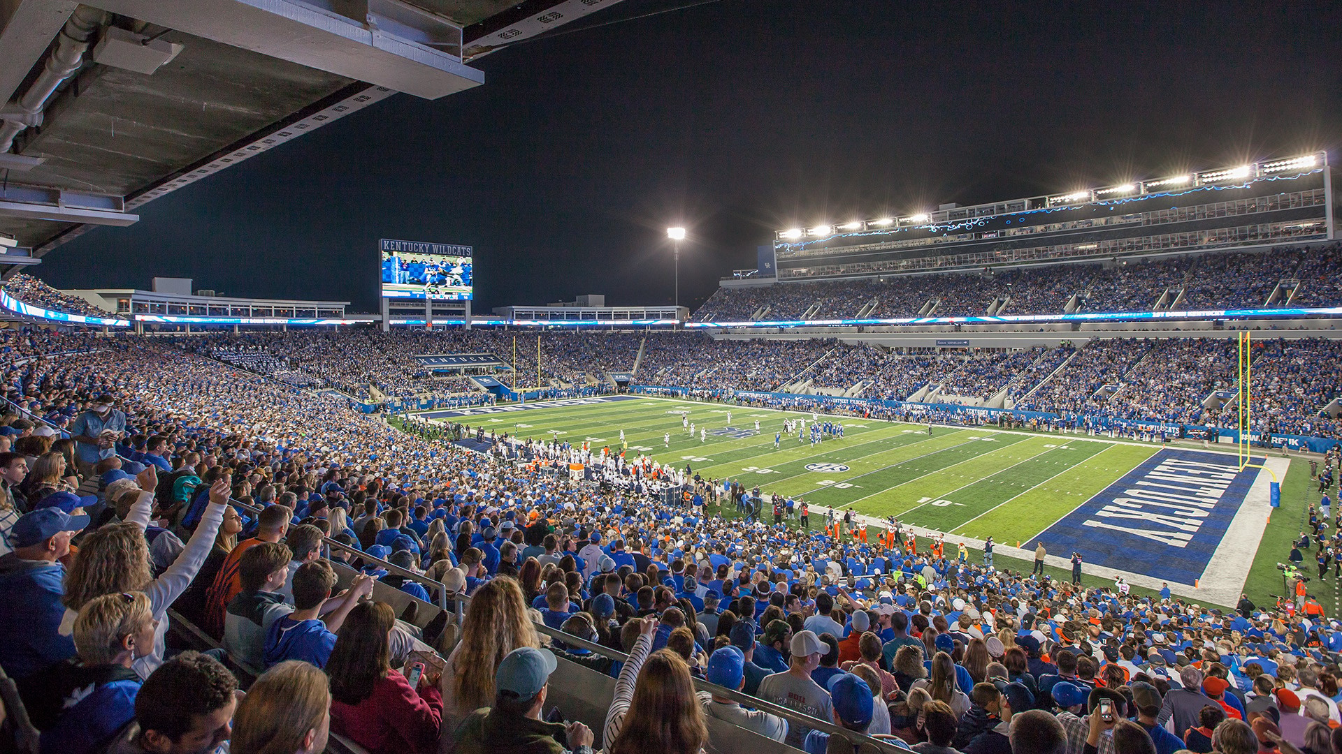 Nigh time football stadium with fans cheering
