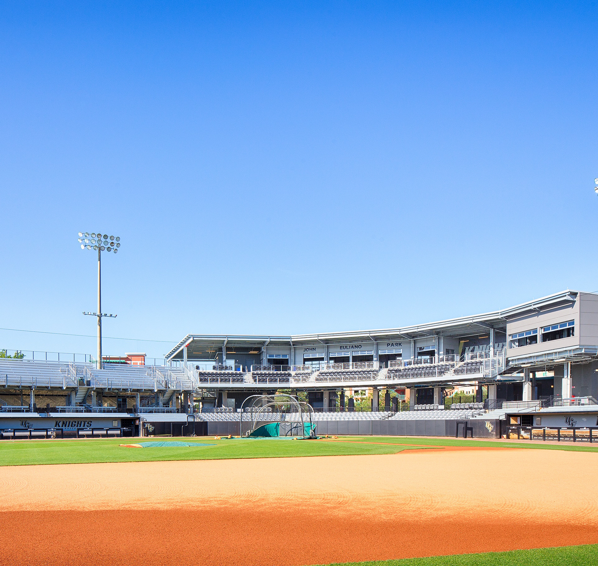 Baseball field with empty stands and clear blue sky at John Fultano Park.