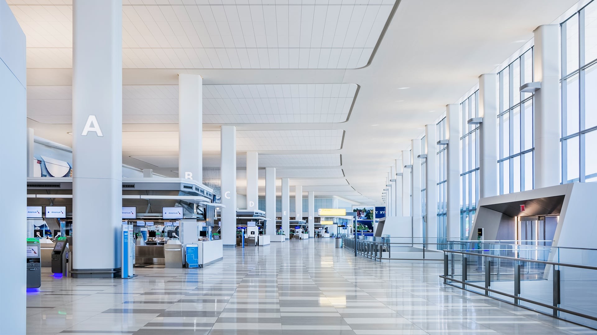 Spacious, modern airport terminal with tall windows and check-in counters.