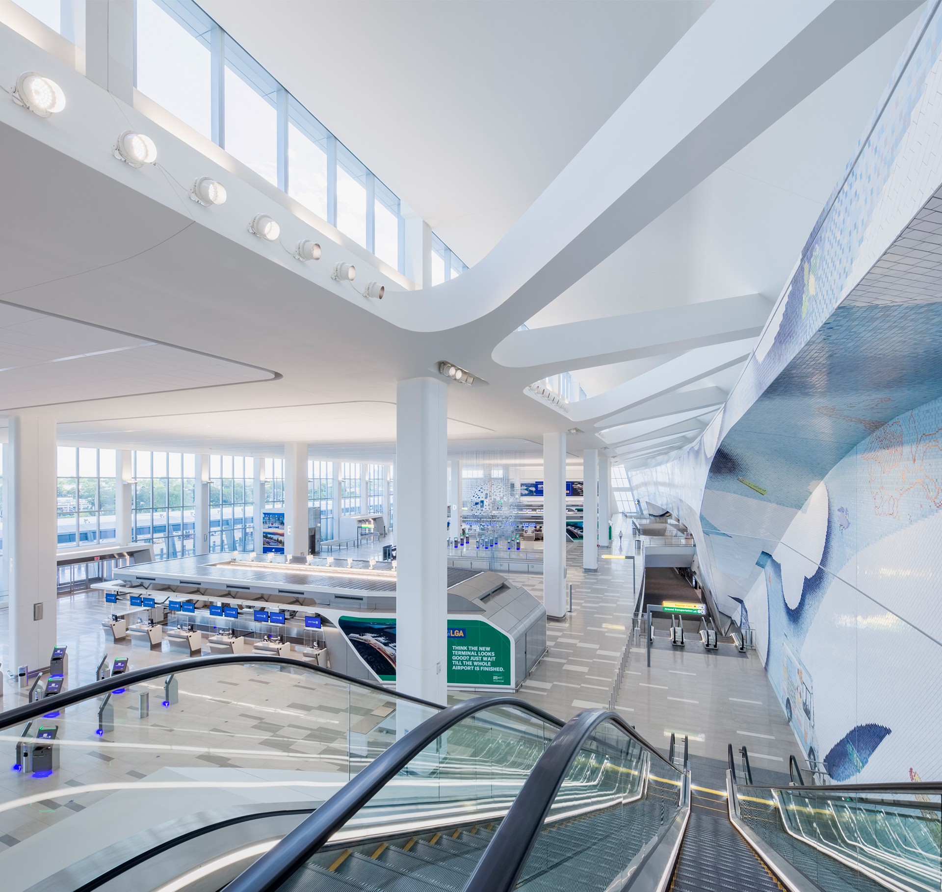 Modern Bright Airport Terminal Interior with Escalator View Bright, modern airport terminal with escalators, check-in counters, and large windows.