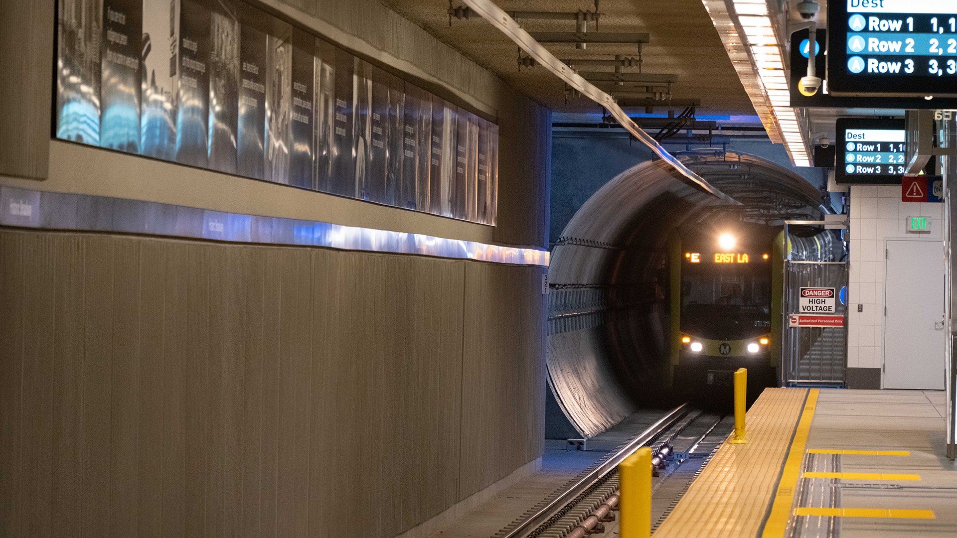 Subway train arriving at an underground station platform with safety yellow markings.