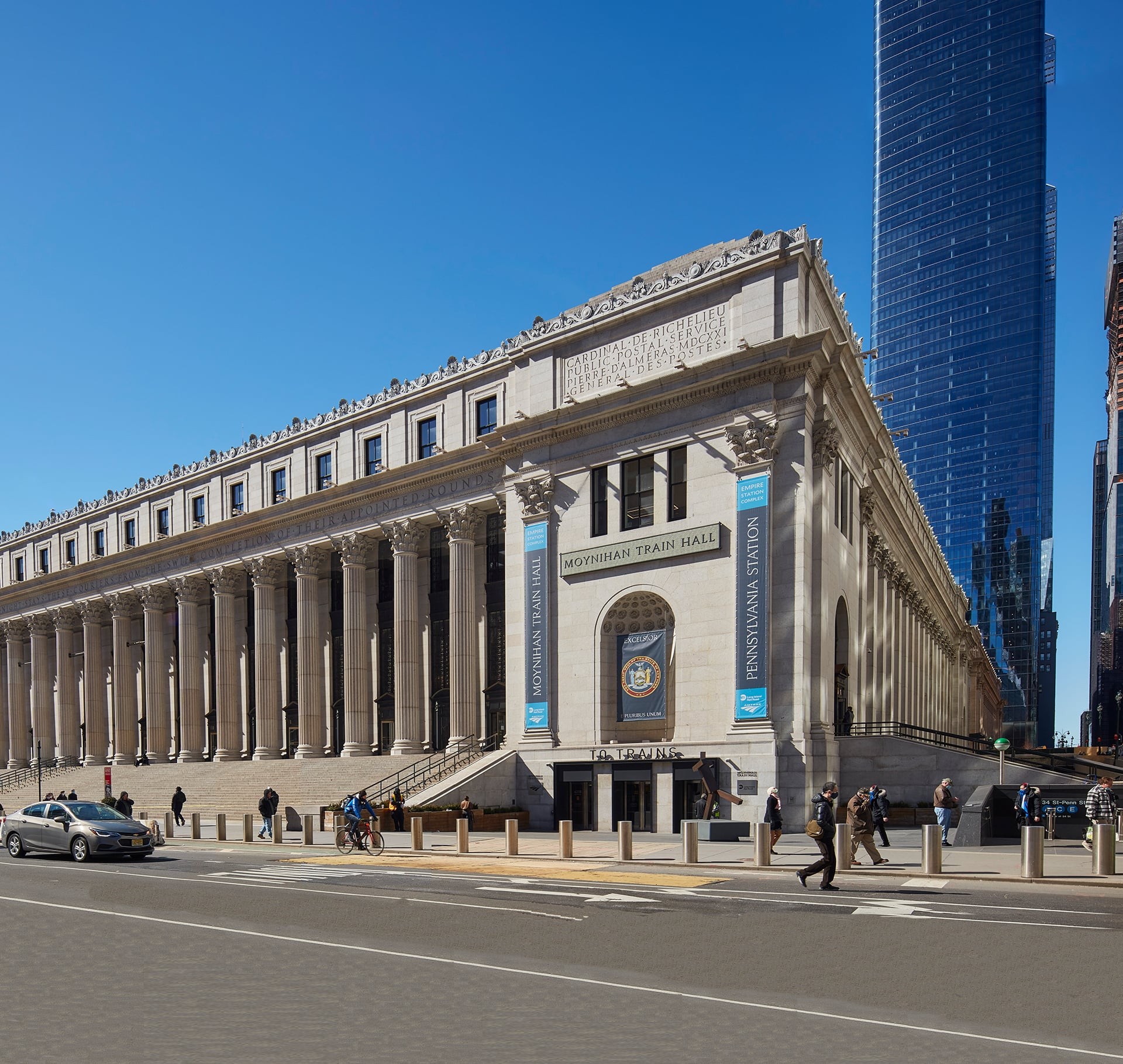 Historic Moynihan Train Hall at Pennsylvania Station NYC Exterior view of Moynihan Train Hall at Pennsylvania Station with a clear blue sky.