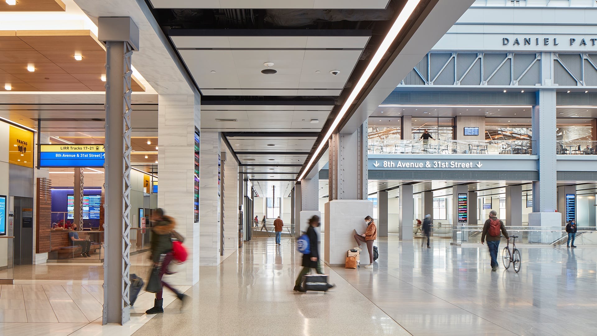 Modern train station interior with travelers walking and signage for 8th Avenue & 31st Street.