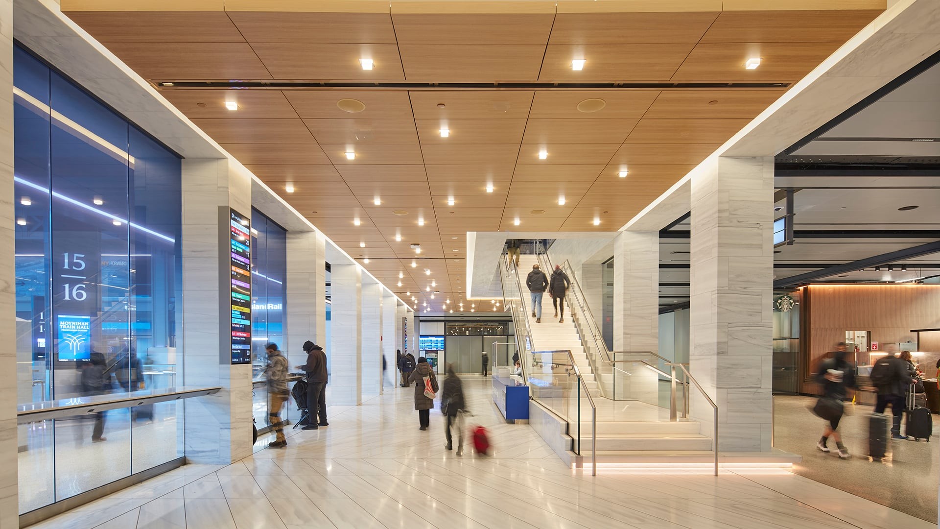 Modern airport terminal interior with travelers and illuminated ceiling lights.