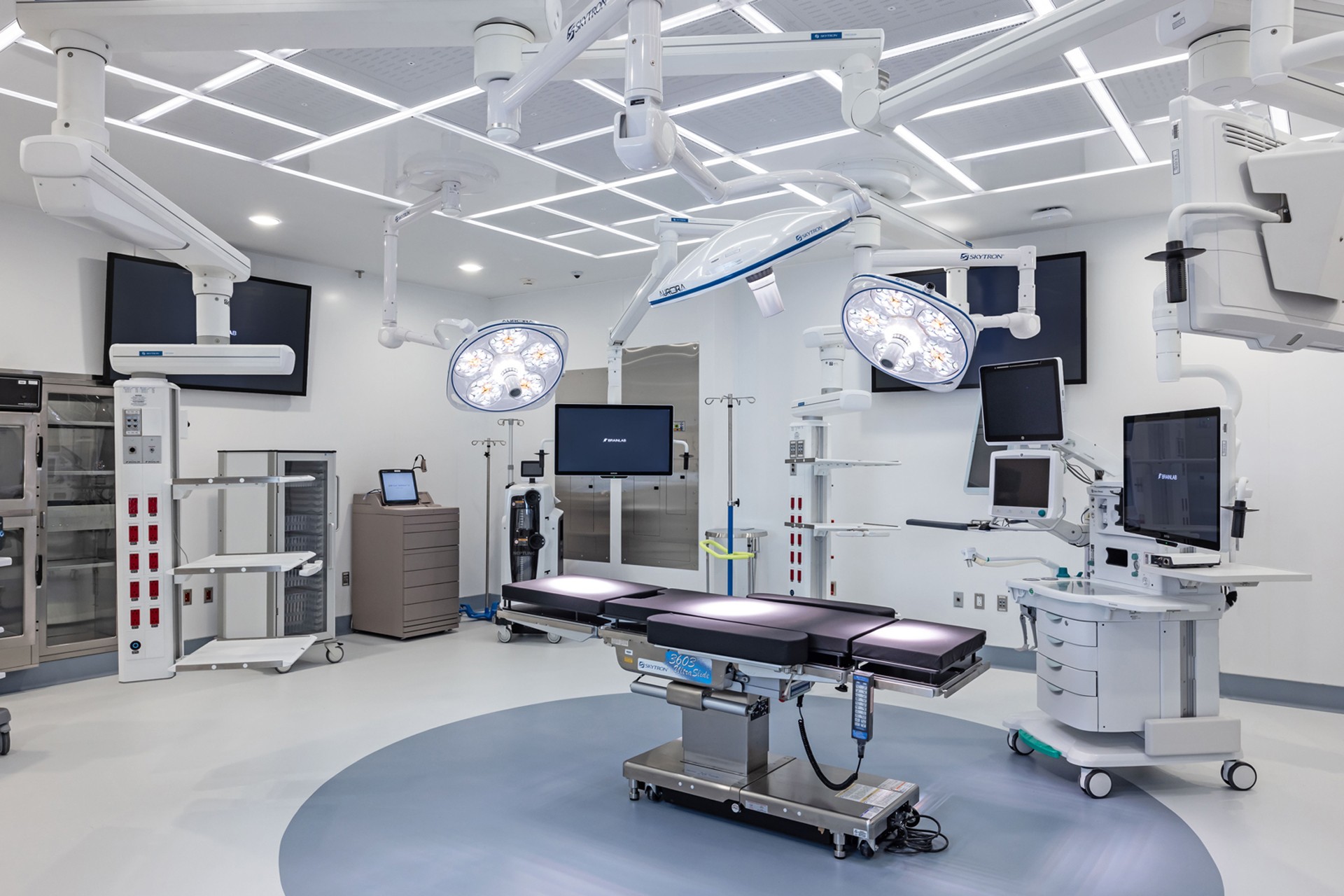 Modern, well-equipped operating room with surgical lights, monitors, and an adjustable table.