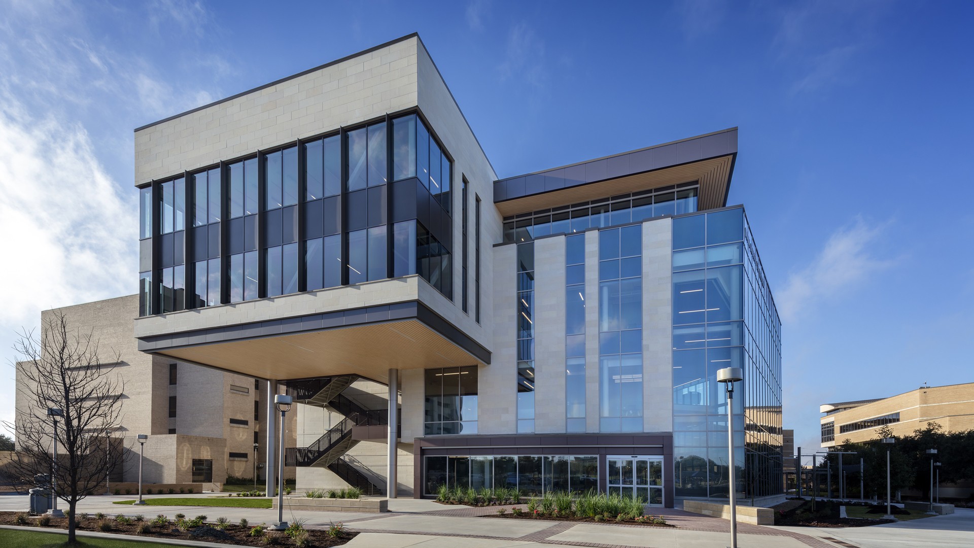 Modern office building with glass facade under a clear blue sky.