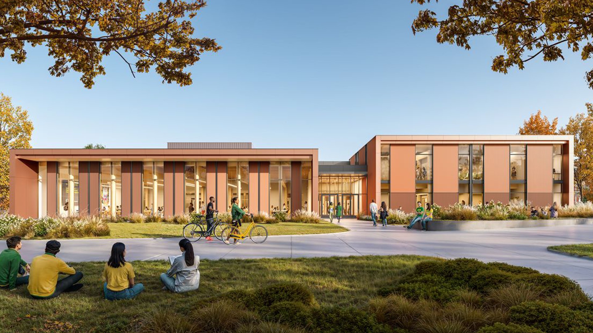 Modern community center with people walking, biking, and sitting on grass outside.