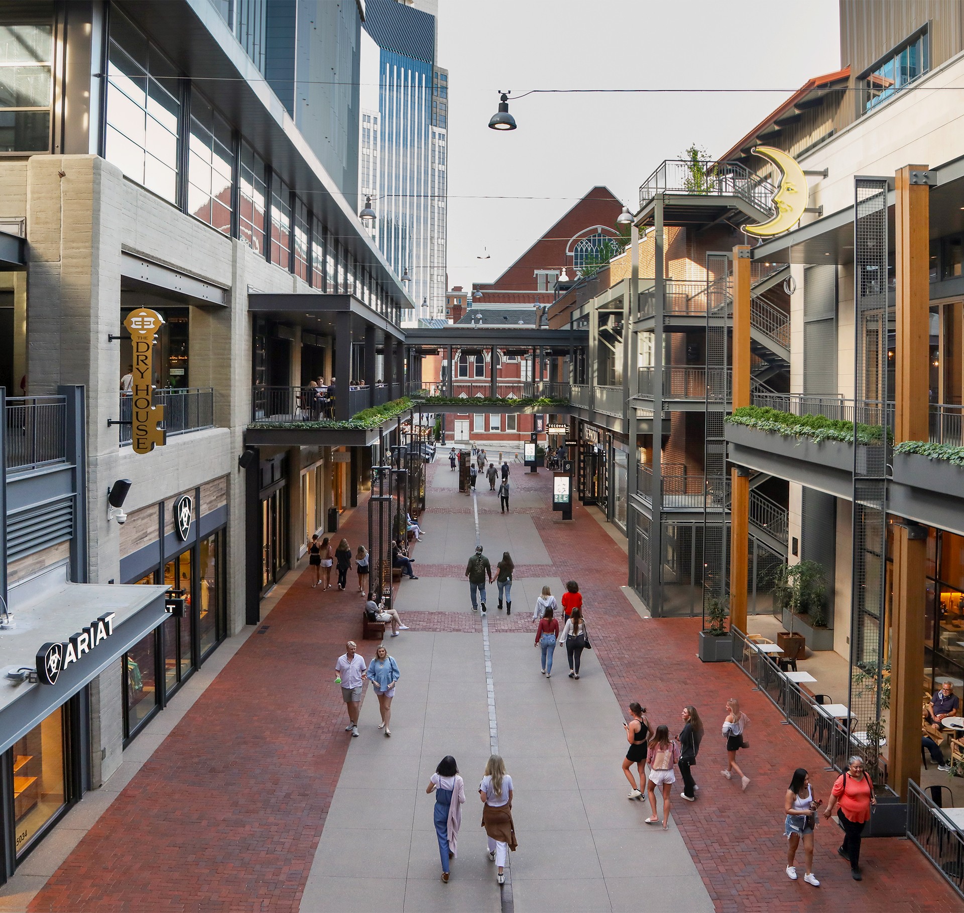 Modern Urban Shopping Street with Pedestrians and Shops Outdoor urban shopping area with pedestrians, modern buildings, and retail stores.