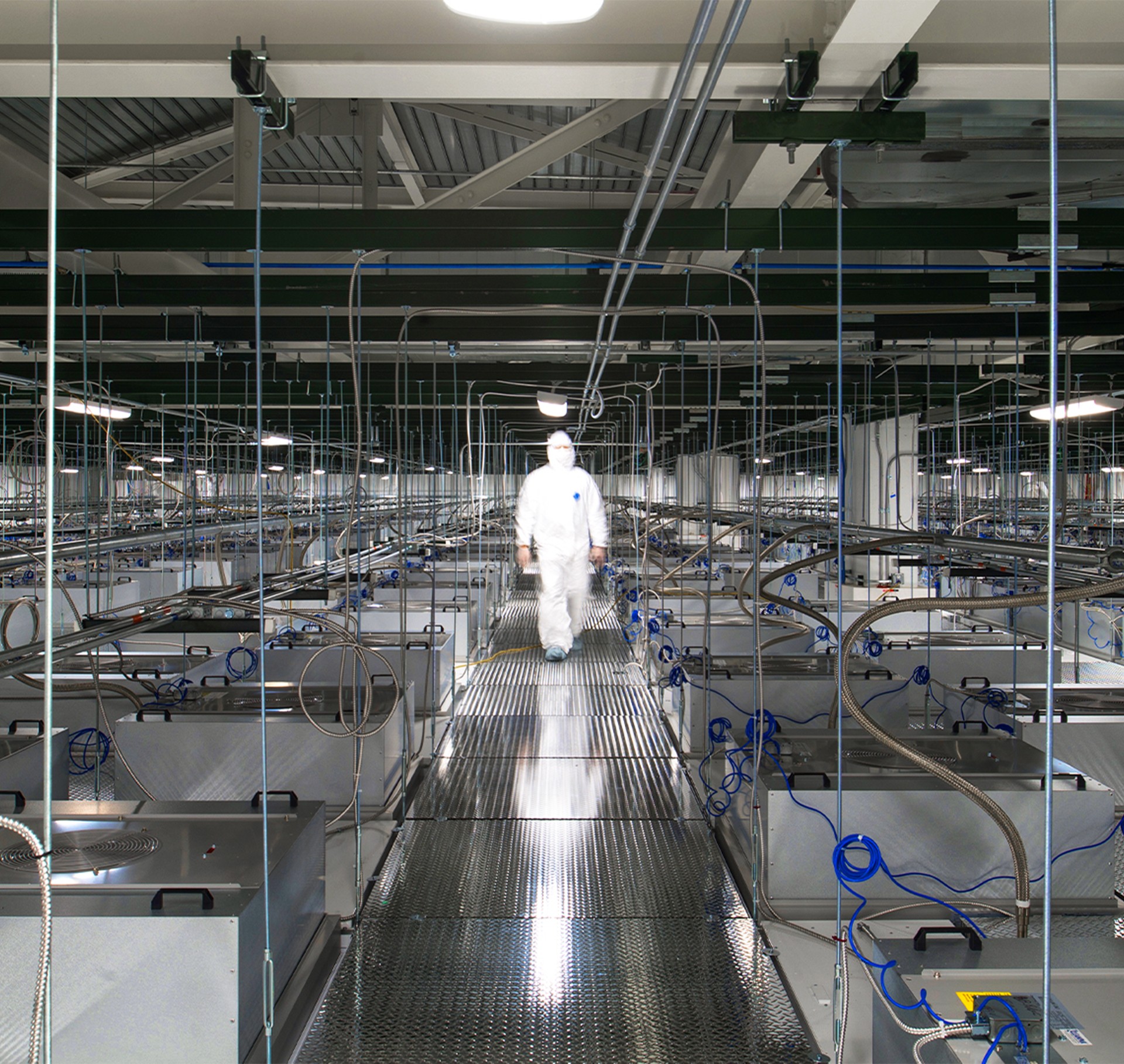 High-tech manufacturing facility with worker in chip suit. High-tech manufacturing facility with worker in chip suit.
