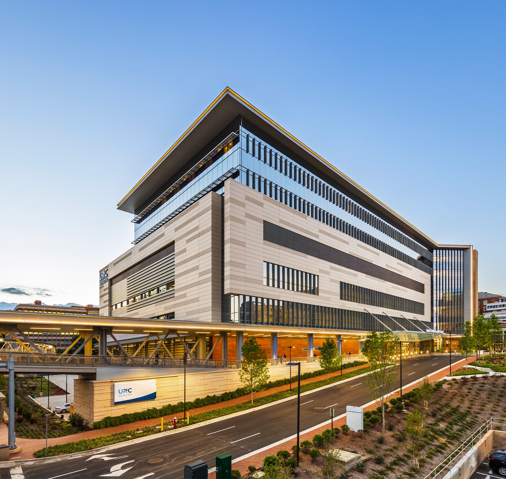 Modern multi-story UPC university building with glass and stone facade under clear sky.