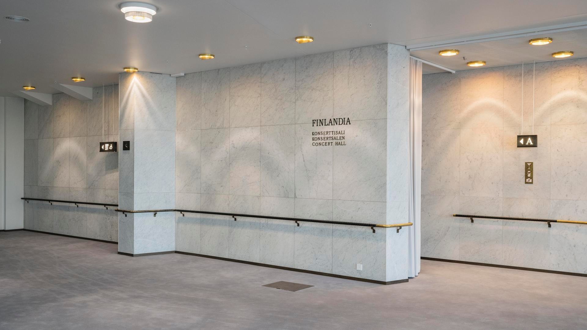 Finlandia-konserttisalin sisustus marmorisilla seinillä, kattovaloilla ja opasteilla.