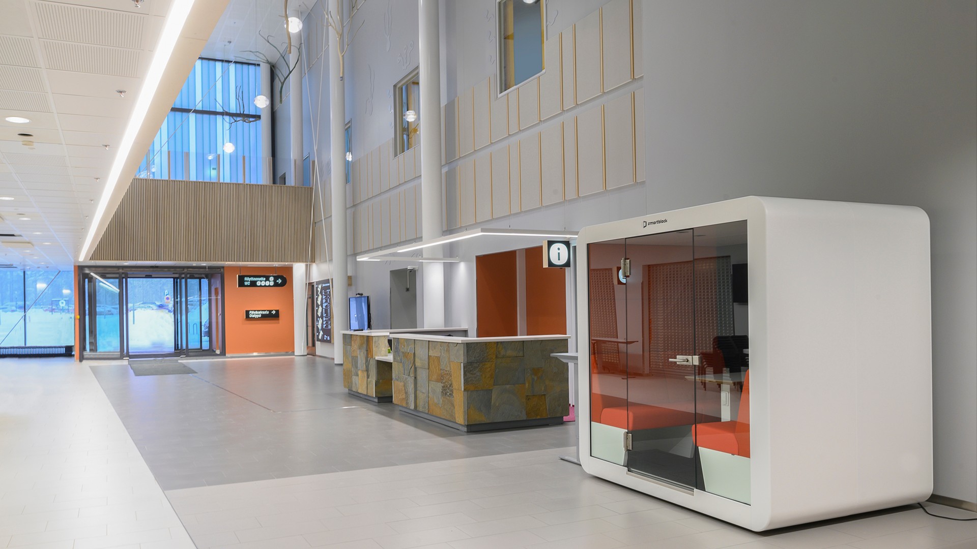 Moderni toimiston aula, jossa on tyylikäs puhelinkoppi ja vastaanottoalue nykyaikaisessa muotoilussa.