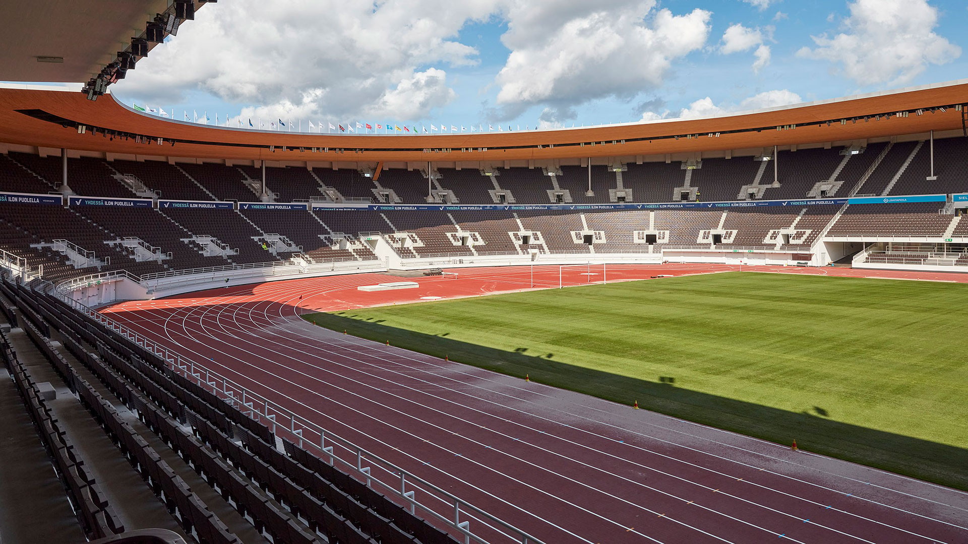 Urheilustadion, jossa on juoksurata ja vihreä kenttä osittain pilvisen taivaan alla.