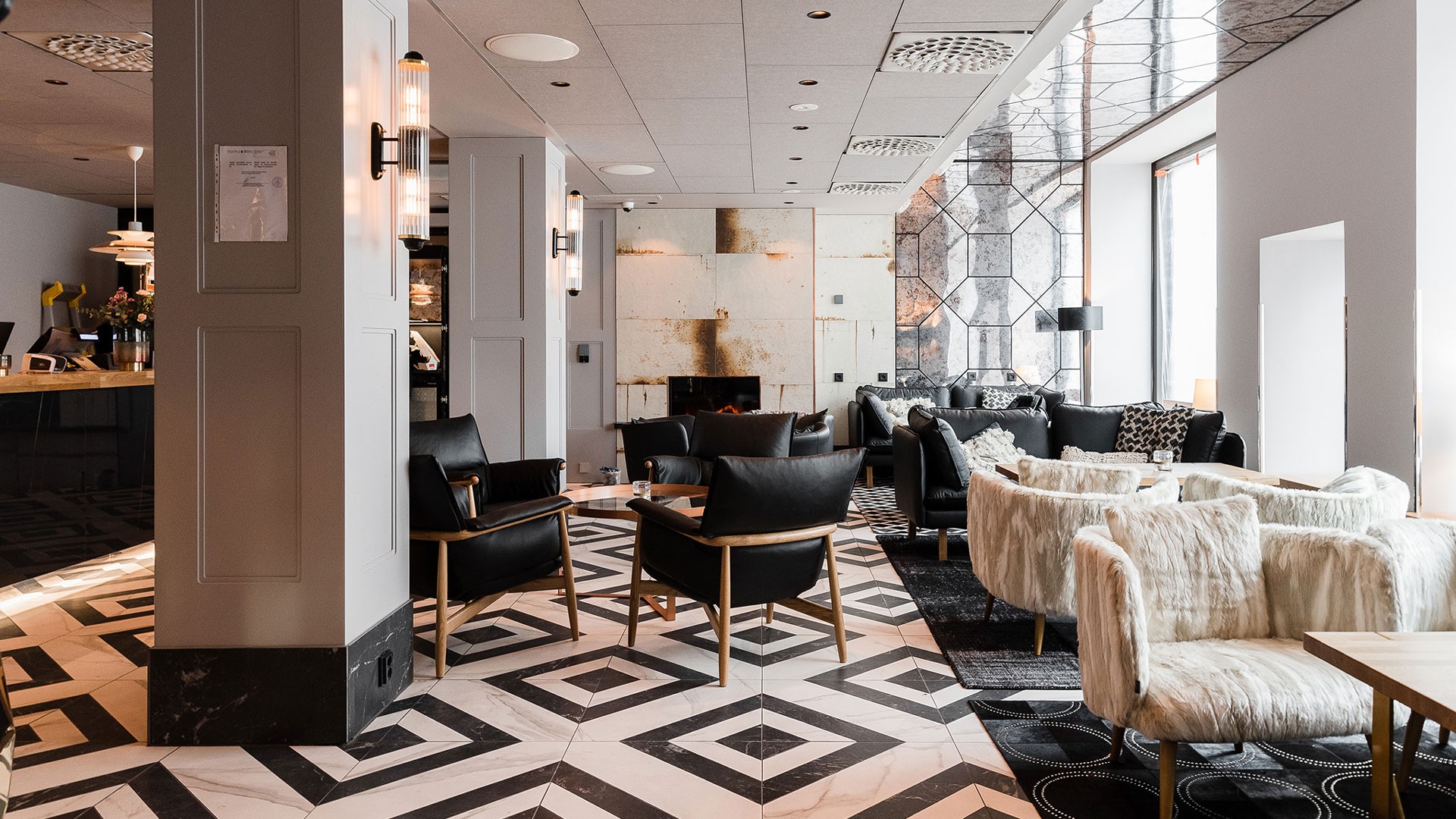 Vastaanoton ja sisäänkäyntiaulan vieressä sijaitsee mukava oleskelualue. Moderni lounge, jossa on geometrinen lattia, mustat tuolit ja pehmeät istuimet, tarjoamassa viihtyisän ilmapiirin.