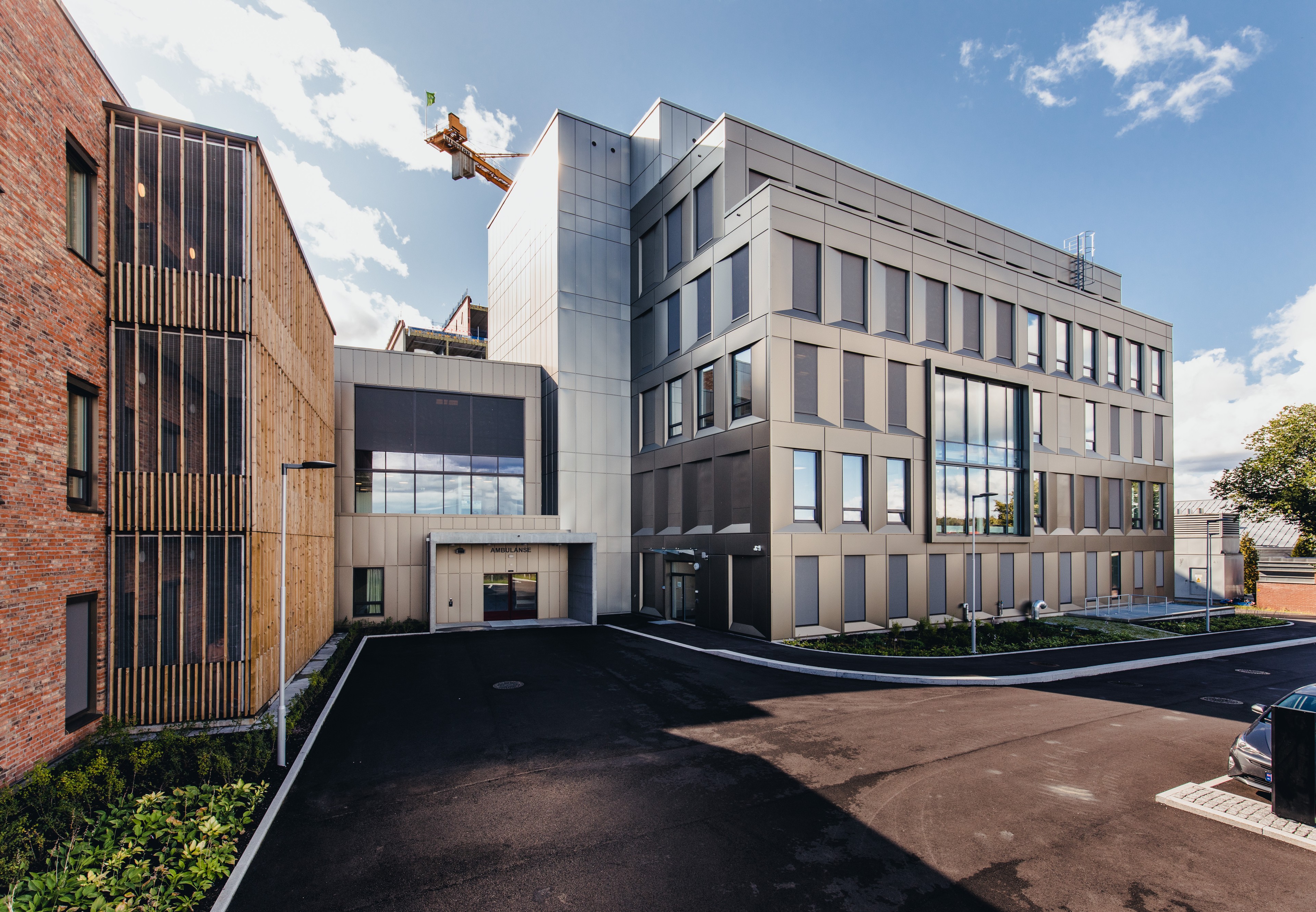 Tønsberg Hospital, Norway Modern multi-story building with diverse materials, surrounded by paved area and landscaping.