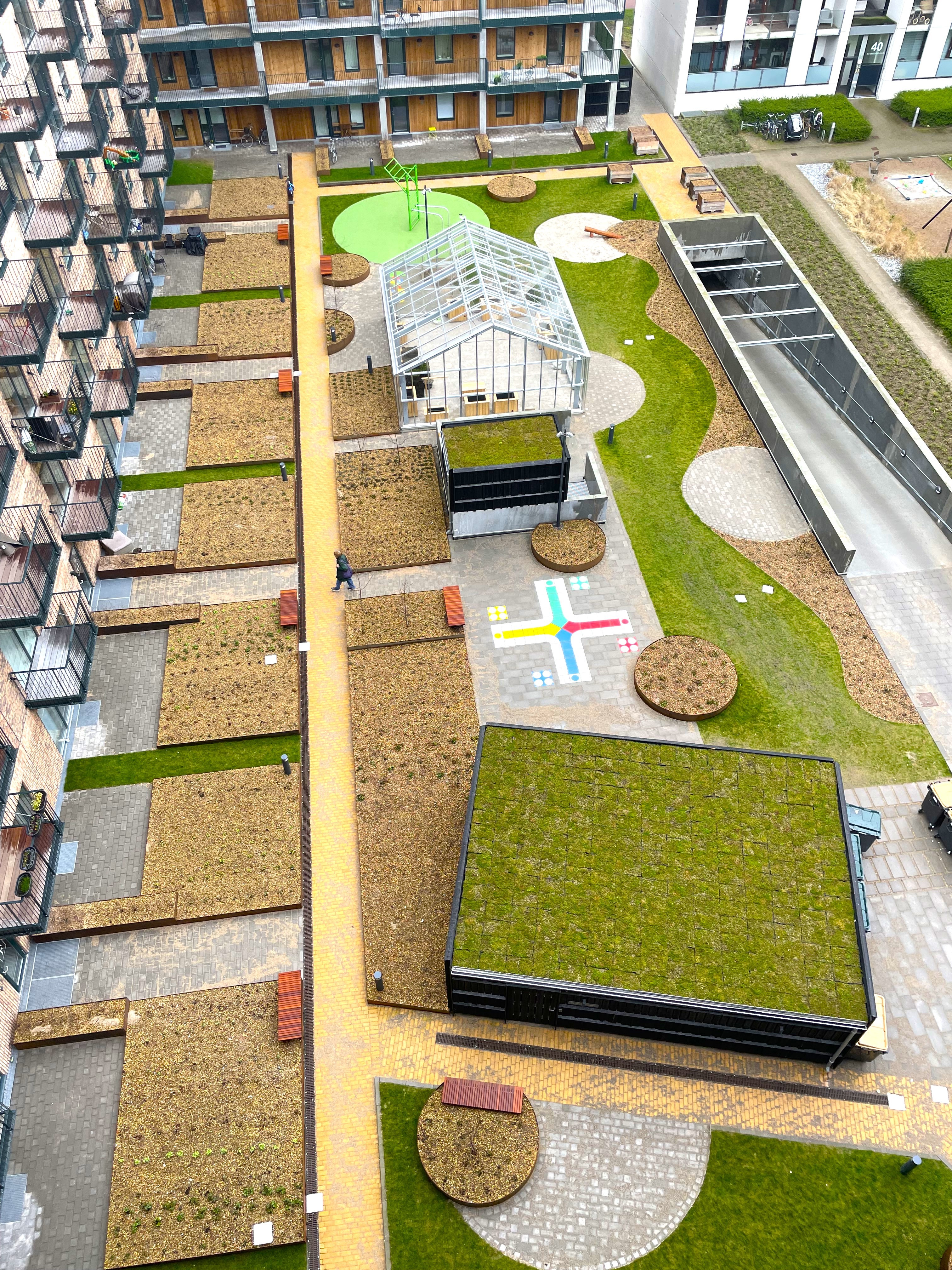 Modern Apartment Courtyard with Green Roofs and Walkways Modern apartment complex courtyard with green roofs, pathways, and seating areas.