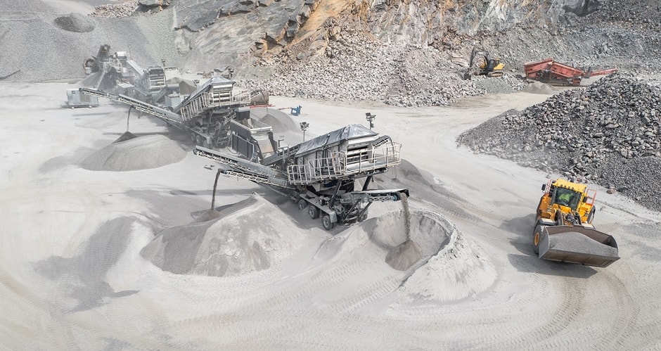 Stor industrimaskin som sorterar grus och sand på en öppen grustäkt.