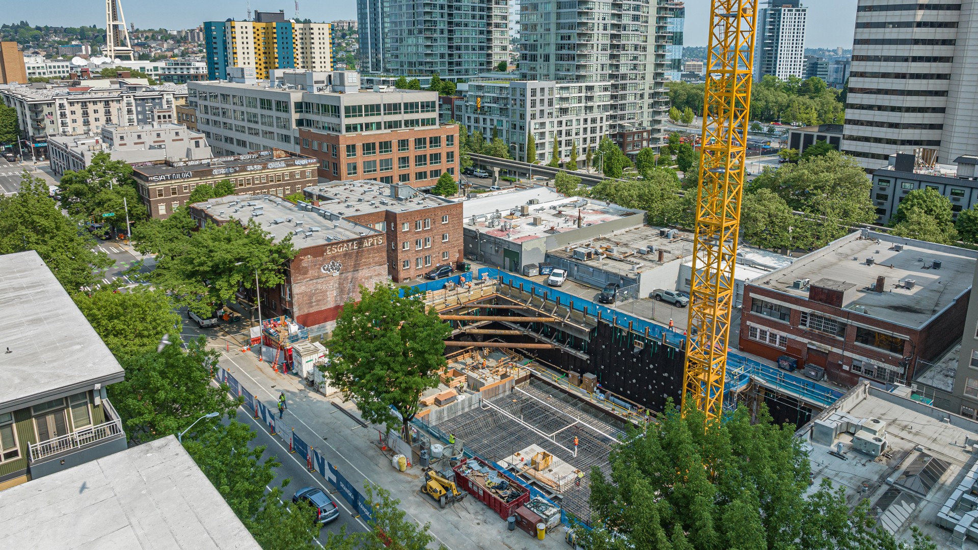 Urban Construction Site in Vibrant Downtown Cityscape Urban construction site with crane and surrounding high-rise buildings in a busy city area.