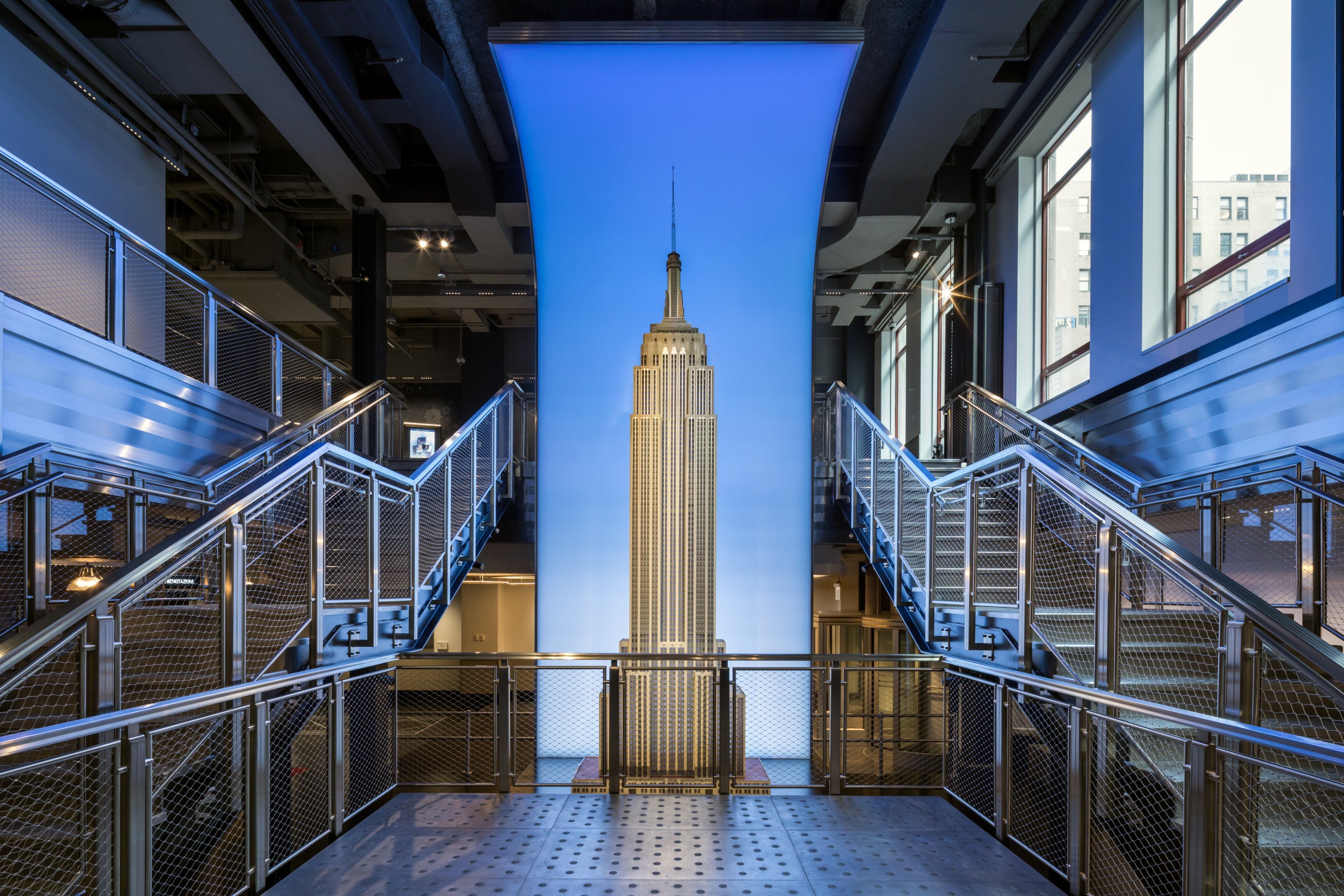 Interior view of a modern building with a large illuminated Empire State Building model.