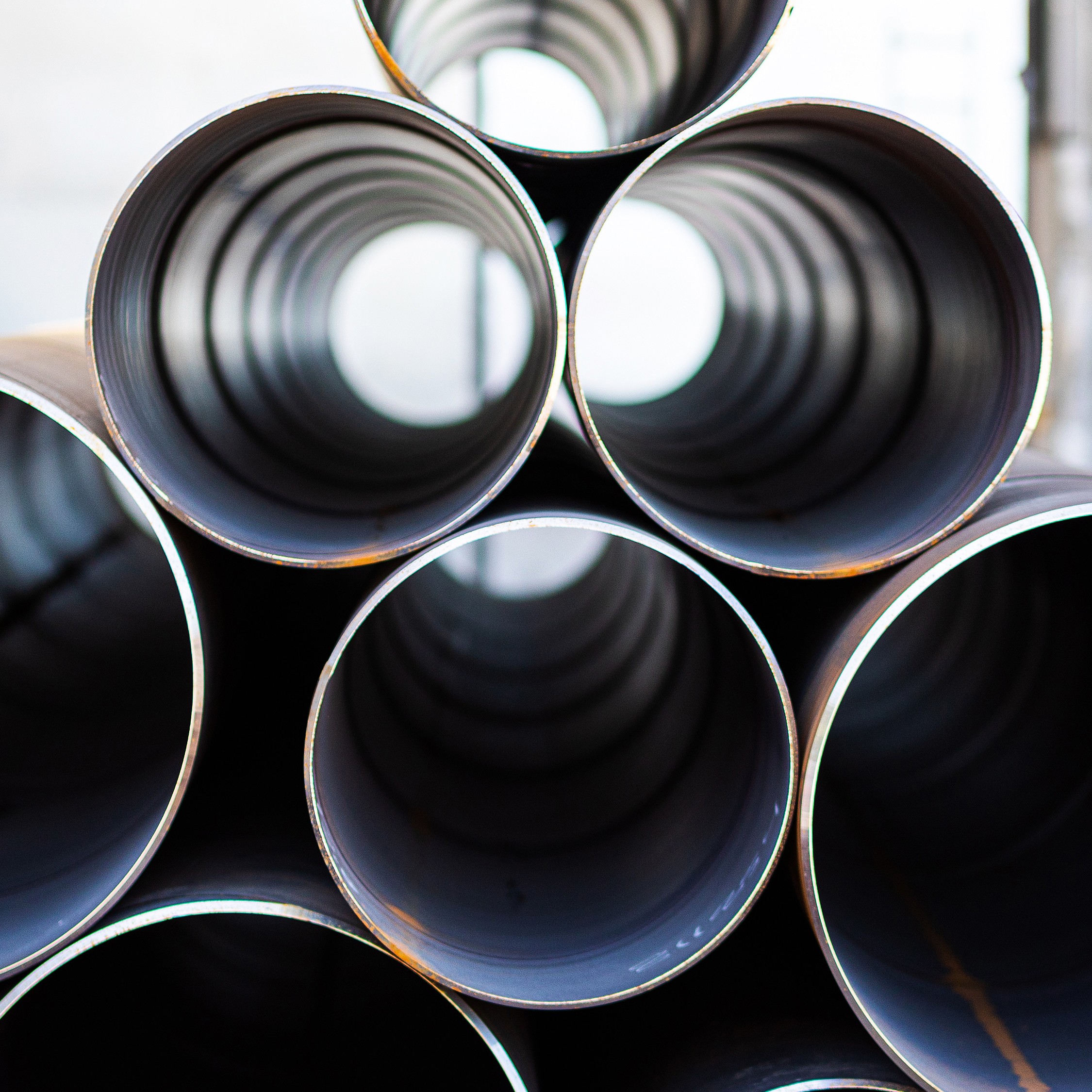 Stablede metallrør sett fra endene, som skaper et symmetrisk mønster med et sentralt fokus.