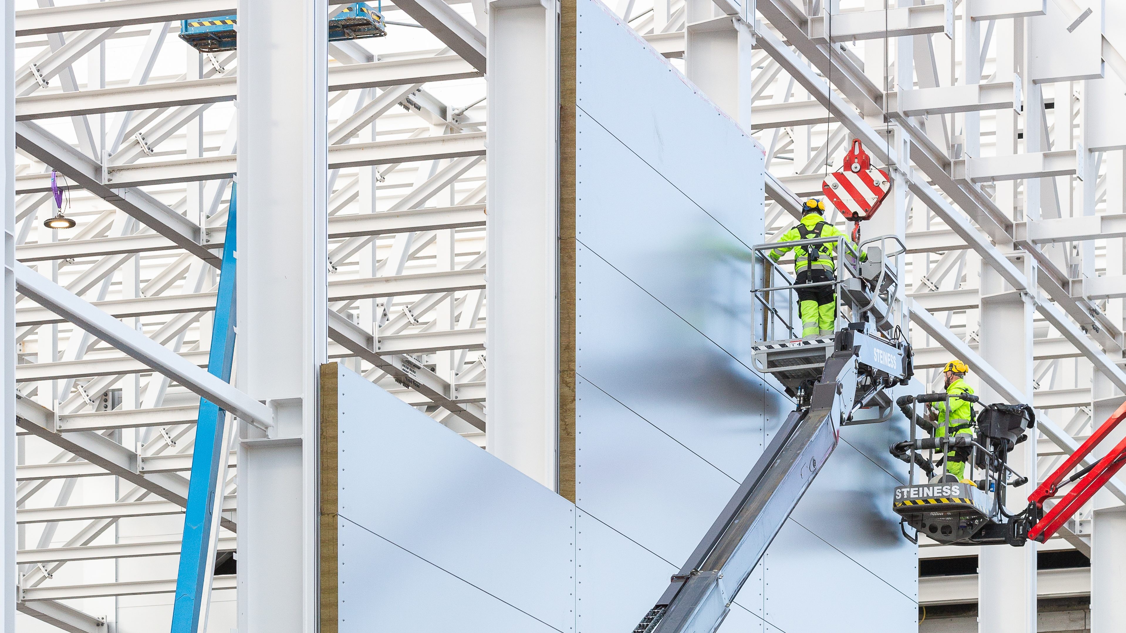 Construction workers installing metal panels on ESS European Spallation Source