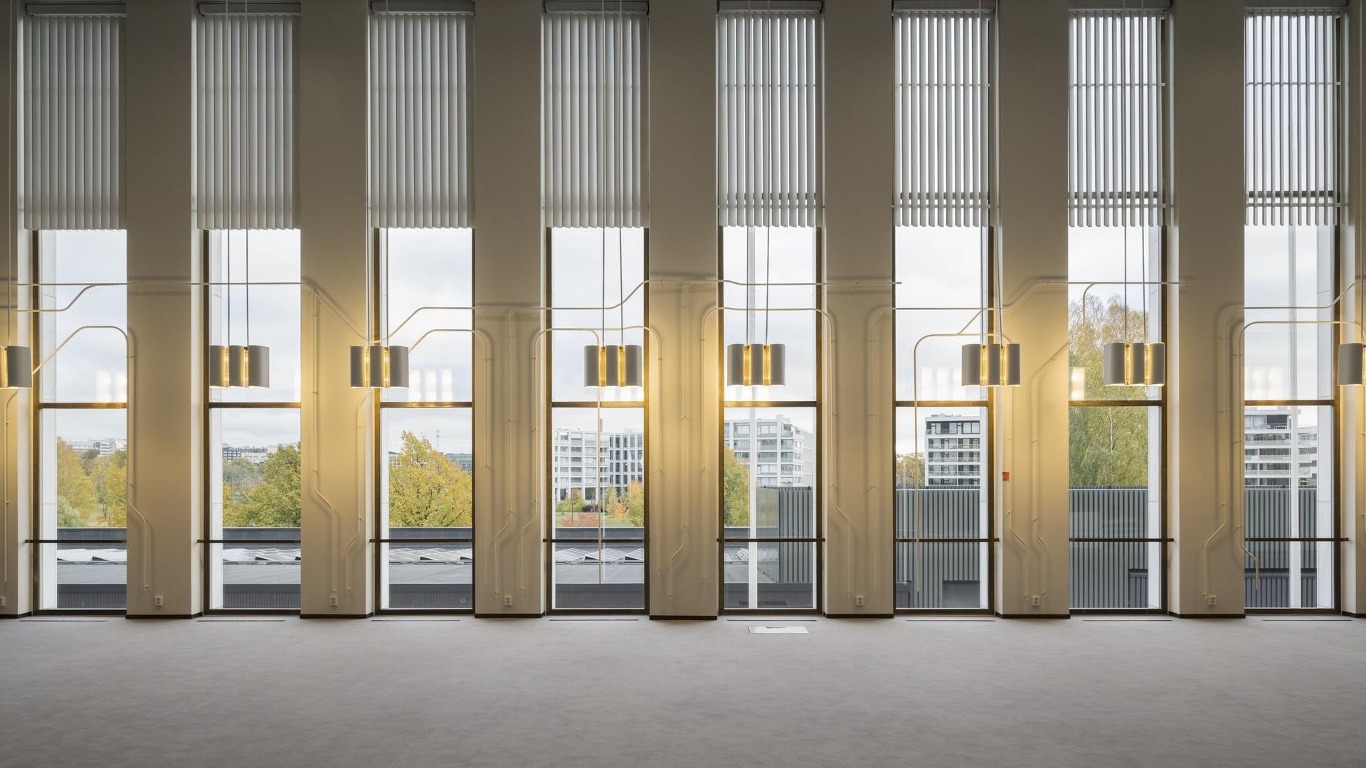 Modern Architectural Interior with Tall Windows and Lighting Modern interior with large windows, vertical blinds, and pendant lights overlooking a cityscape.