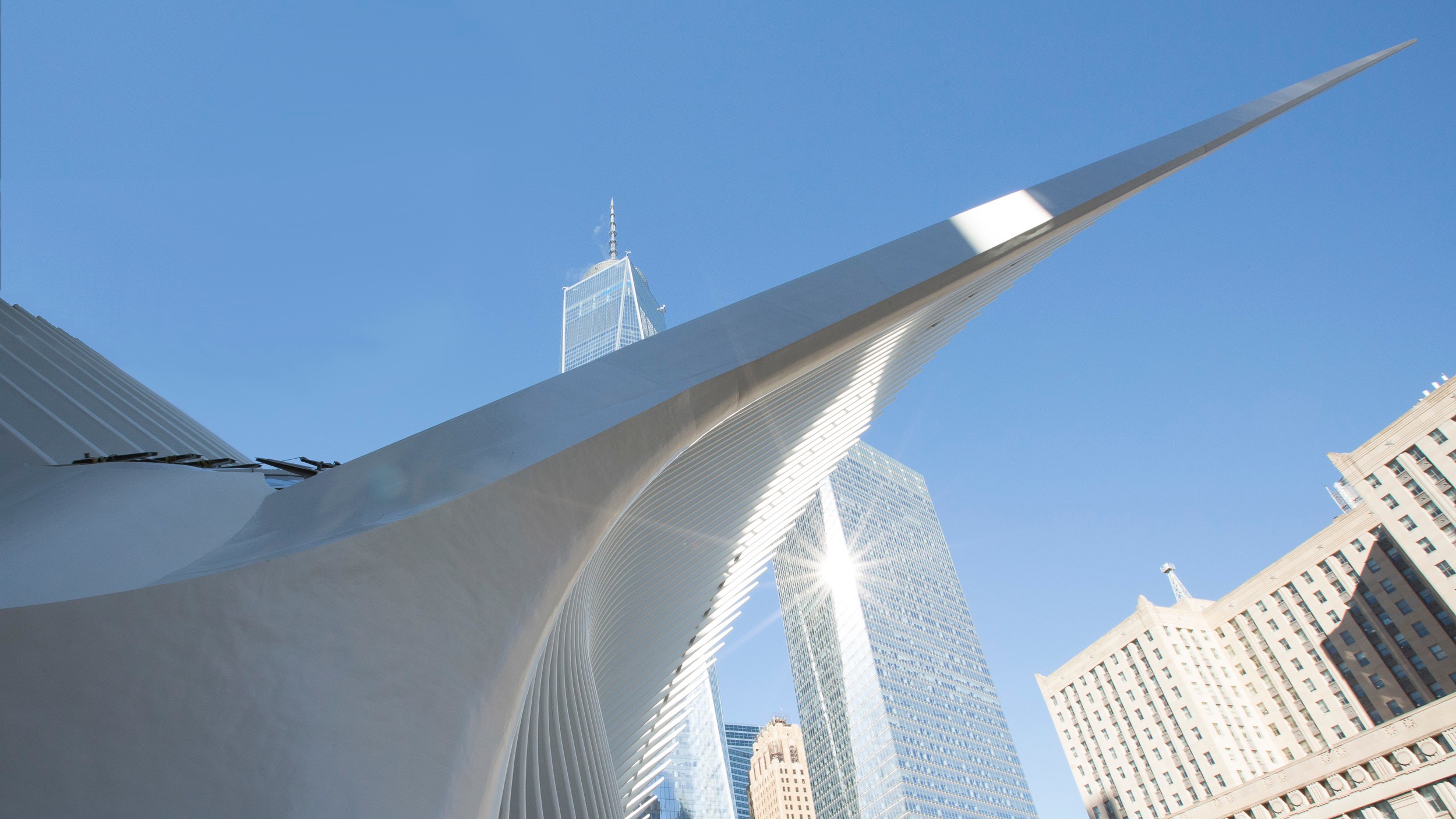 Modern white architectural structure with sharp angles against a clear blue sky.