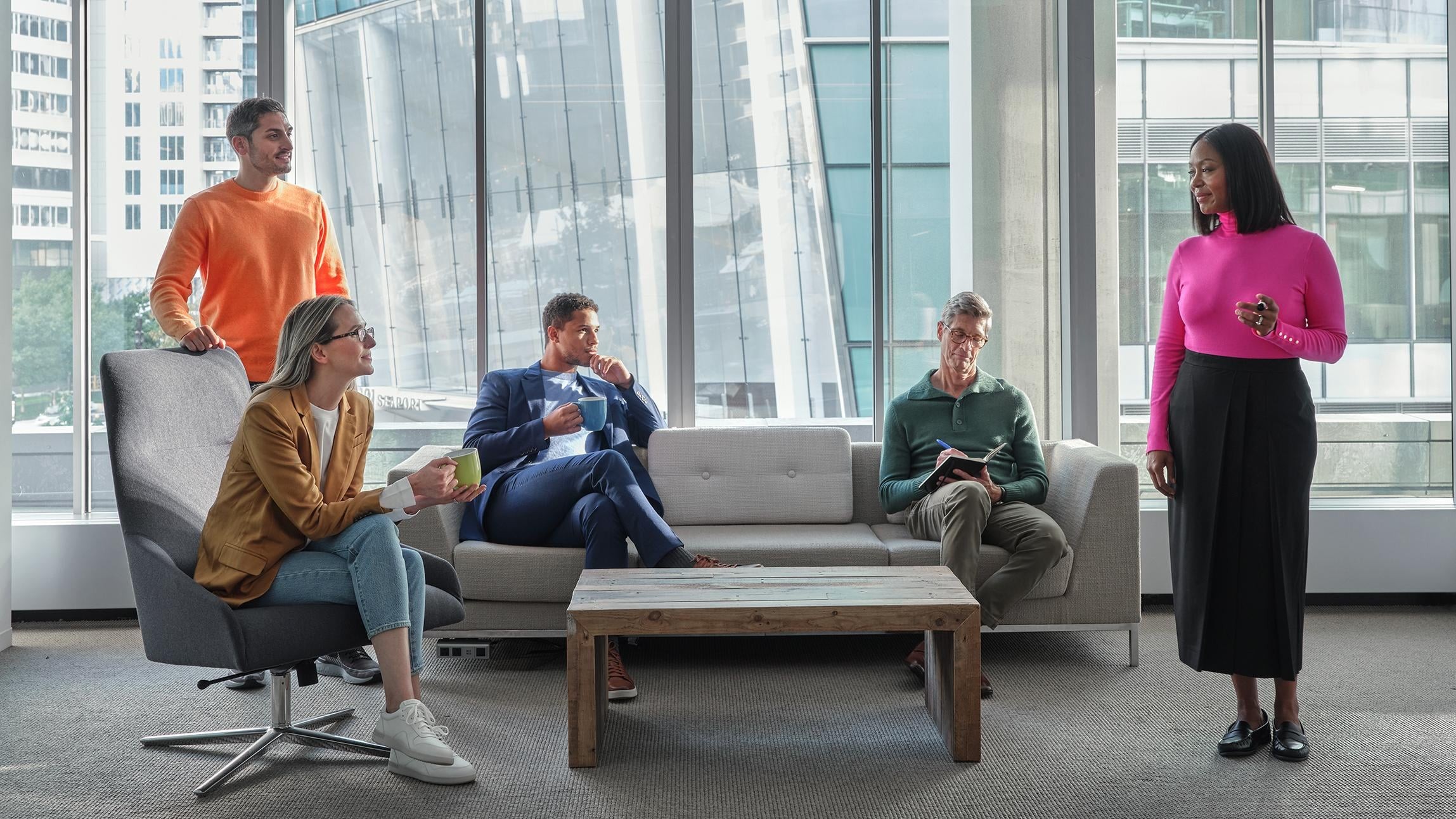 Group of diverse professionals having a casual meeting in a modern office lounge.