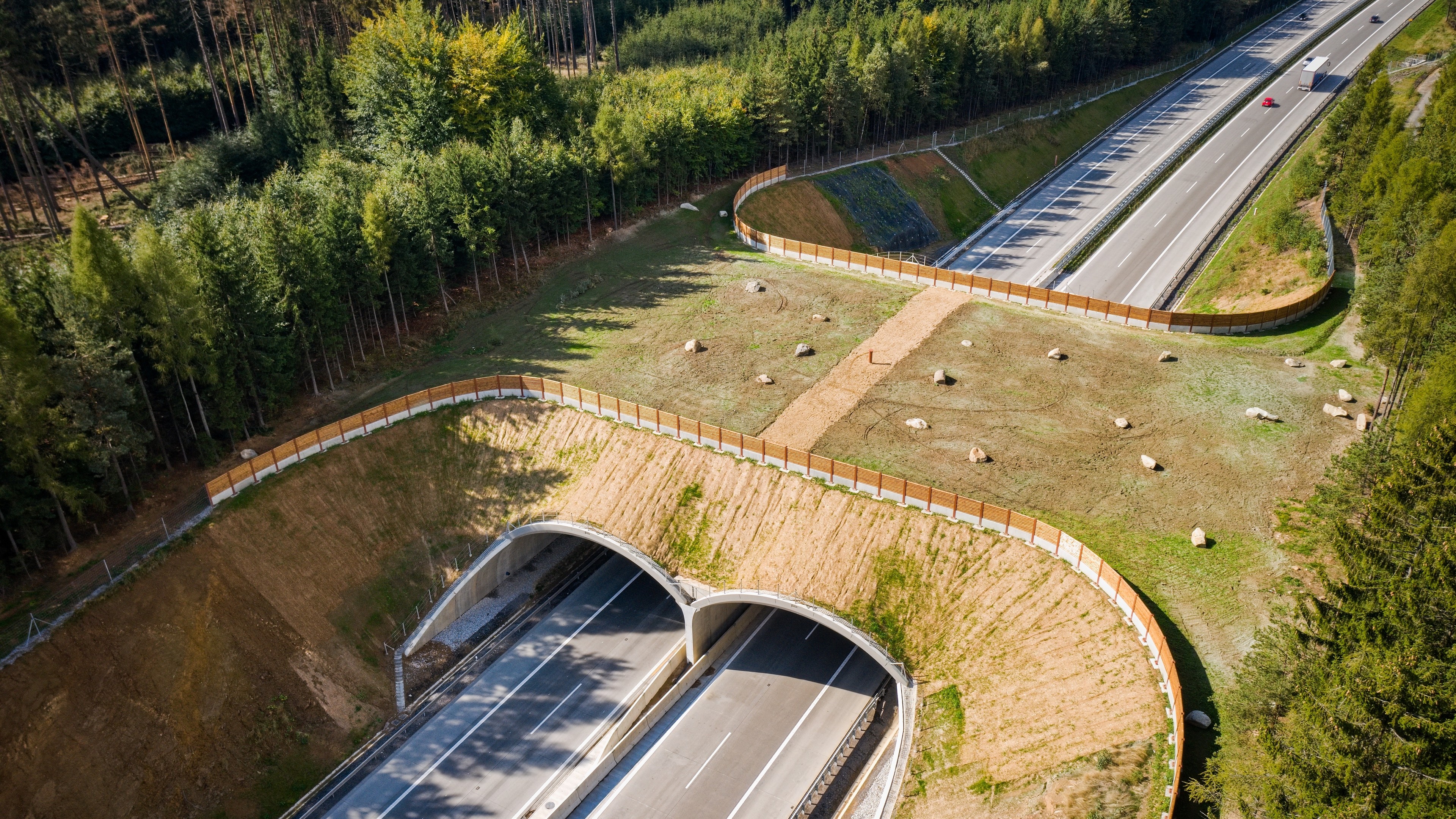 An ecoduct with wildlife overpass on the D1 highway Wildlife overpass with fencing and greenery above a highway tunnel in a forest area.