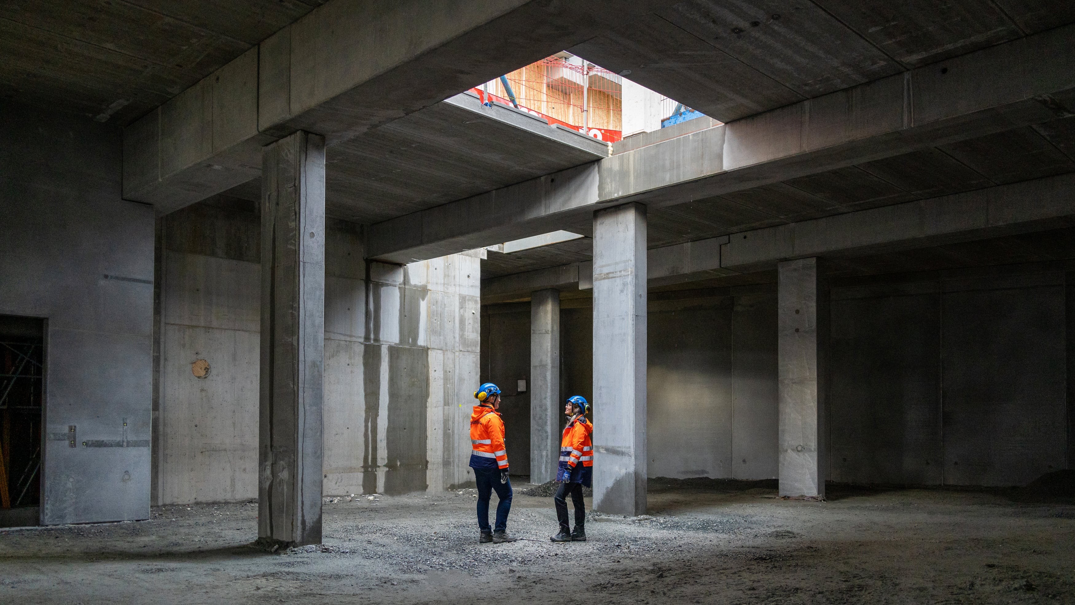 Construction Site Inspection with Safety Gear To bygningsarbeidere i verneutstyr inspiserer en betongkonstruksjon under bygging.