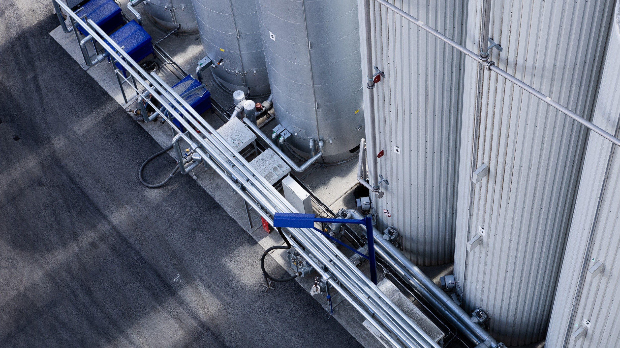 Industriella tankar och rör i en anläggning, som visar stora cylindriska lagringsenheter.