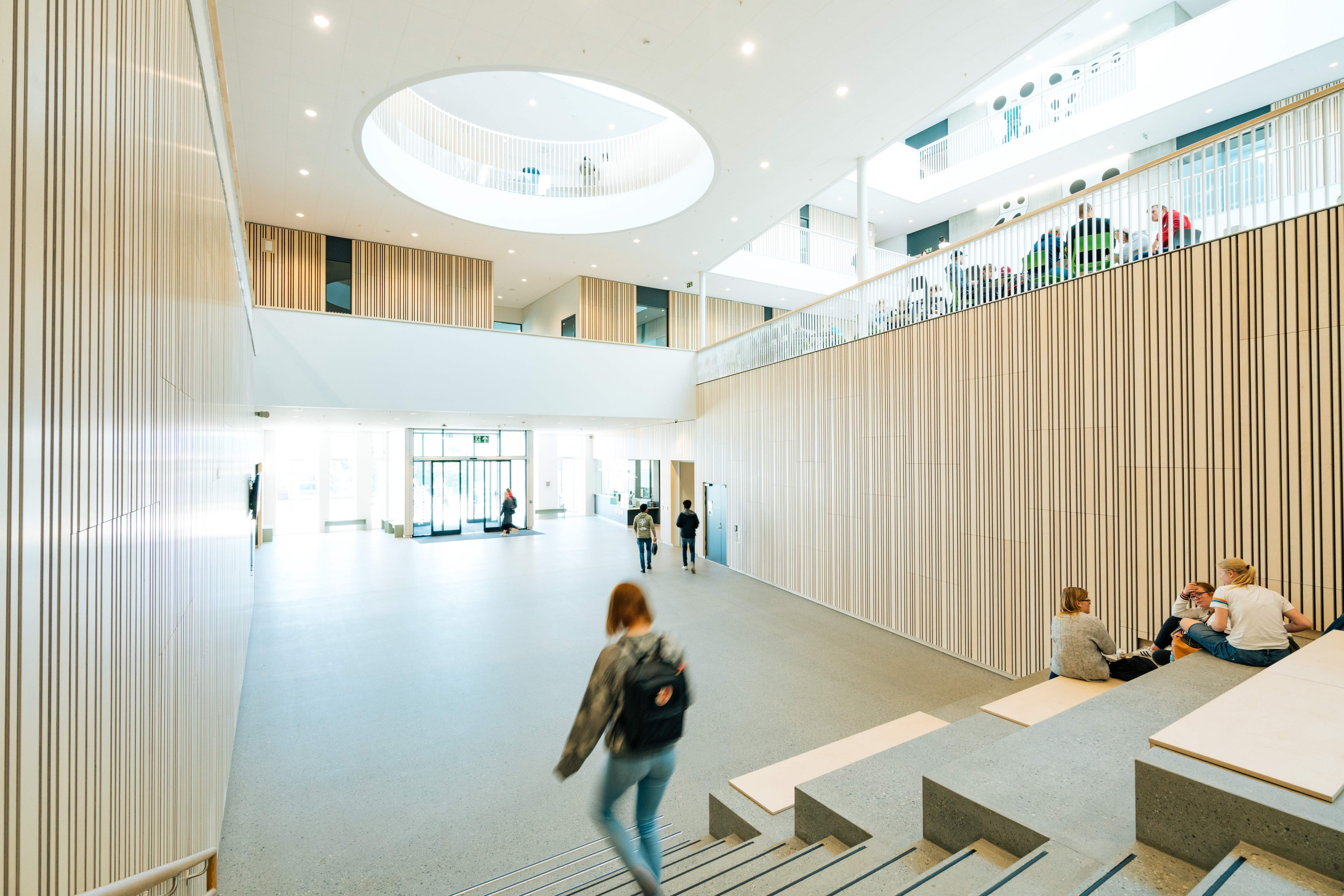 Modern school atrium with students and open spaces Modern atrium with students, with terracing and skylights, promoting a collaborative environment.