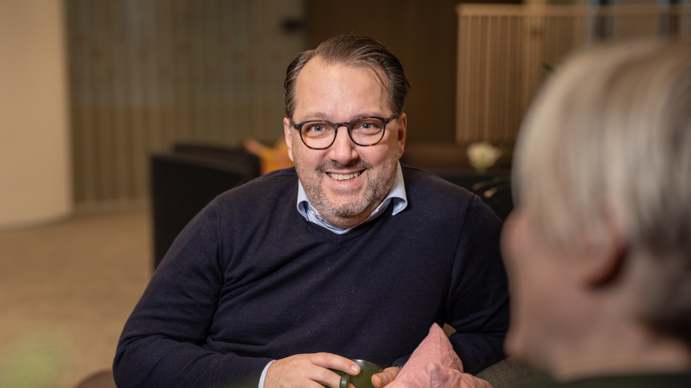 Affärsmöte i modern kontorsmiljö Två personer deltar i samtal i en modern, varmt upplyst interiörmiljö.