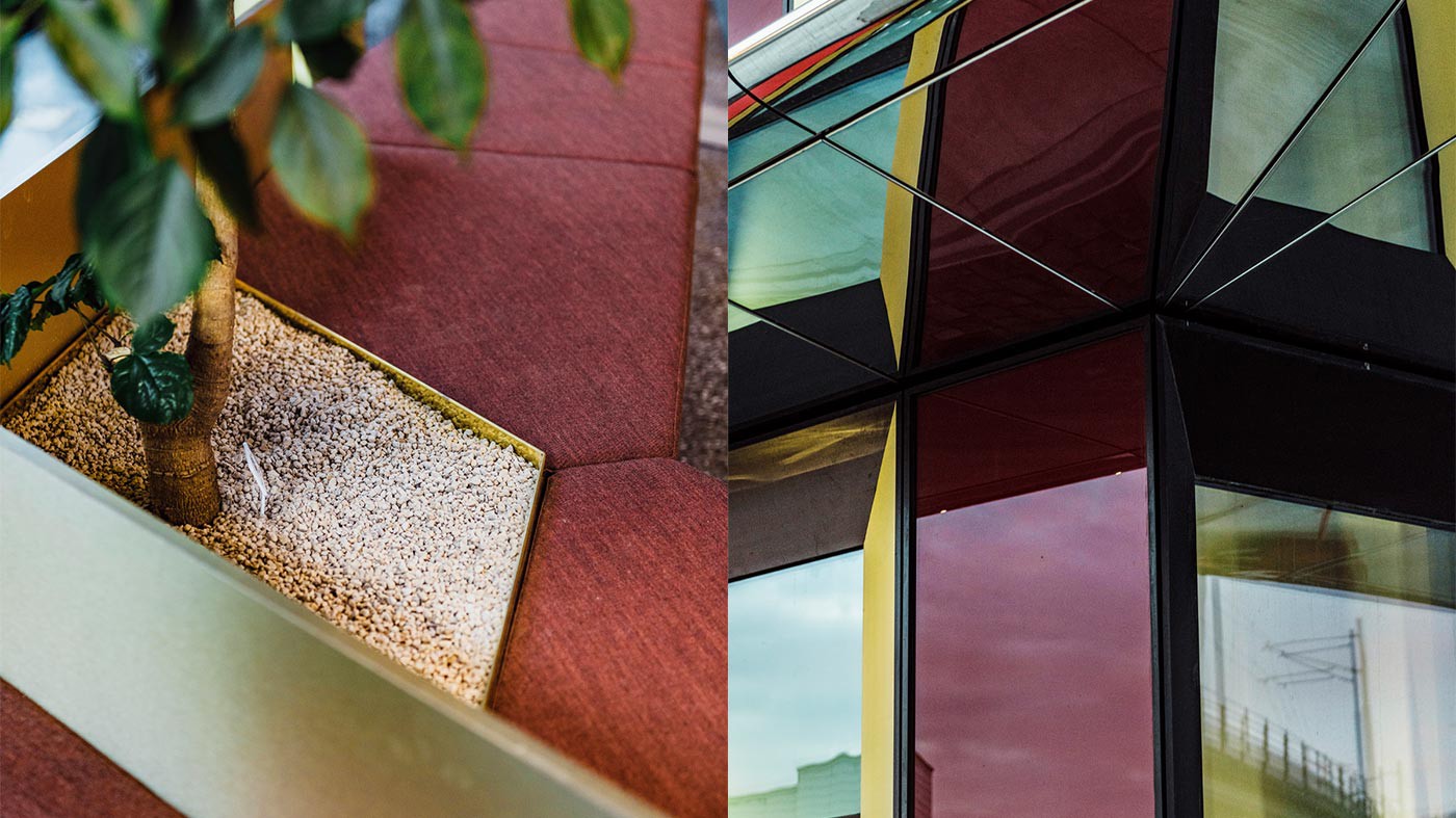 Modern arkitektonisk design: Livfulla färger och texturer En närbild av en modern arkitektonisk design med geometriska former och ett träd planterat i grus.