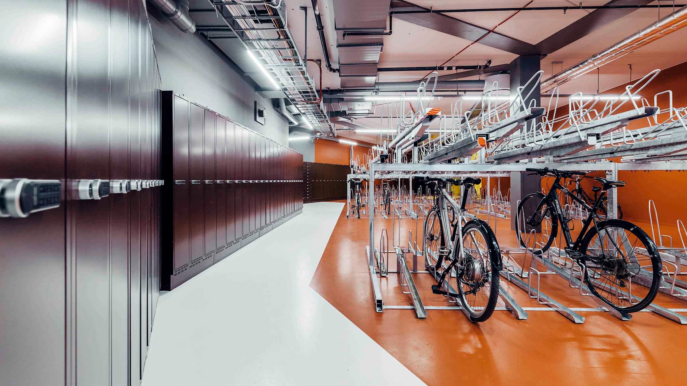 Modern inomhusförvaring för cyklar med skåp och ställ Modern inomhuscykelförvaringsområde med säkrade skåp och ställ för organiserad cykelparkering.