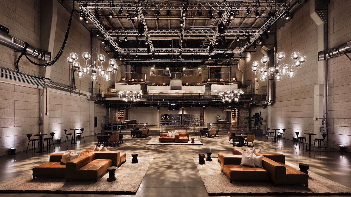 Modern industrilokal med elegant sittarrangemang Rymlig, modern eventlokal med stilfulla sittplatser, eleganta ljuskronor och en sofistikerad atmosfär.
