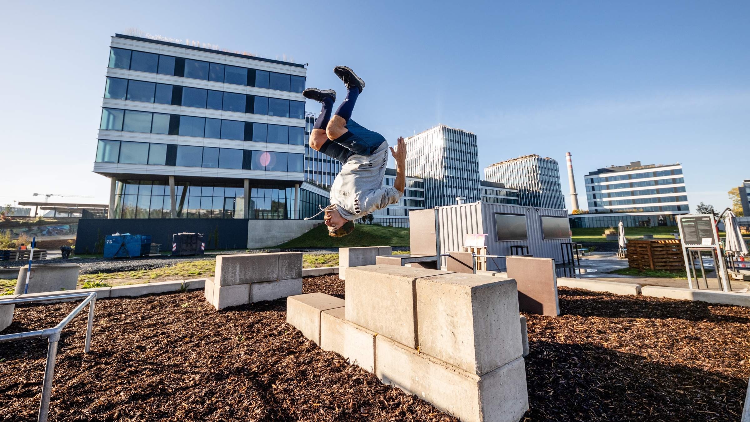 Person som utför en bakåtvolt över betongblock i en urban parkourmiljö.