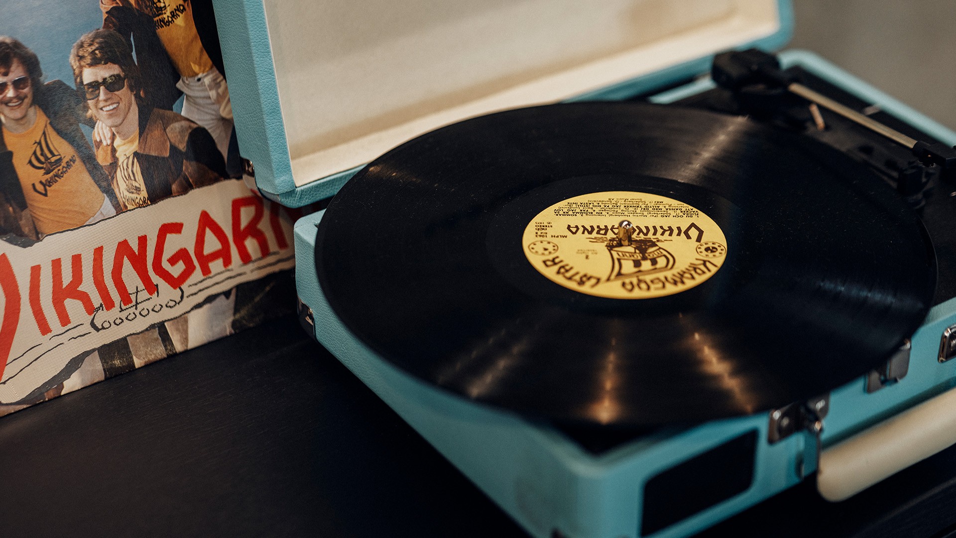 Vintage vinylskivspelare med Vikingarna albumomslag Vintage skivspelare med ett Vikingarna-album i ett blått fodral, som framhäver retro-musikvibbar.